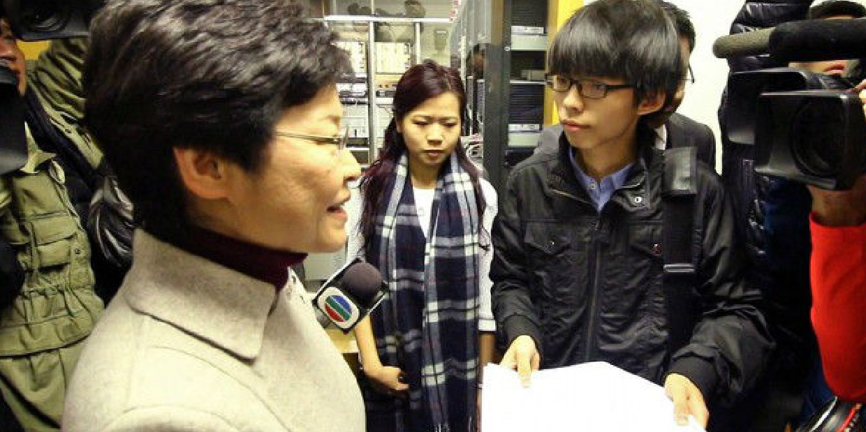 Student leader Joshua Wong confronts Chief Secretary Carrie Lam at Hong Kong Commercial Radio. Photo: Epoch Times Student leader Joshua Wong confronts Chief Secretary Carrie Lam at Hong Kong Commercial Radio. Photo: Epoch Times