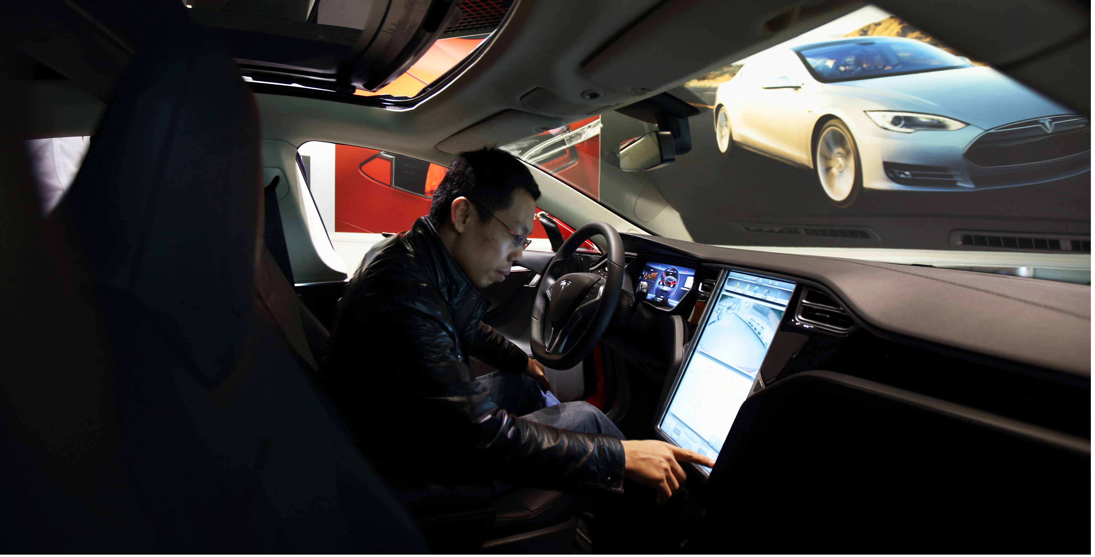 A customer tries the touchscreen console inside Tesla's Model S electric vehicle at a showroom in Beijing. The car created a sensation when it hit the Chinese market last year. Photo: Bloomberg A customer tries the touchscreen console inside Tesla's Model S electric vehicle at a showroom in Beijing. The car created a sensation when it hit the Chinese market last year. Photo: Bloomberg