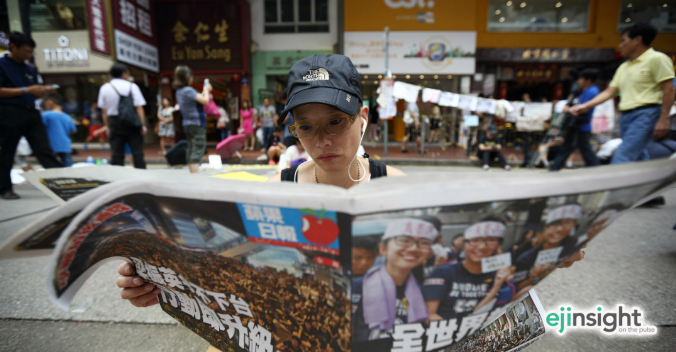 A pro-democracy activist reads Apple Daily at the height of the Occupy protests last year. Photo: Bloomberg A pro-democracy activist reads Apple Daily at the height of the Occupy protests last year. Photo: Bloomberg