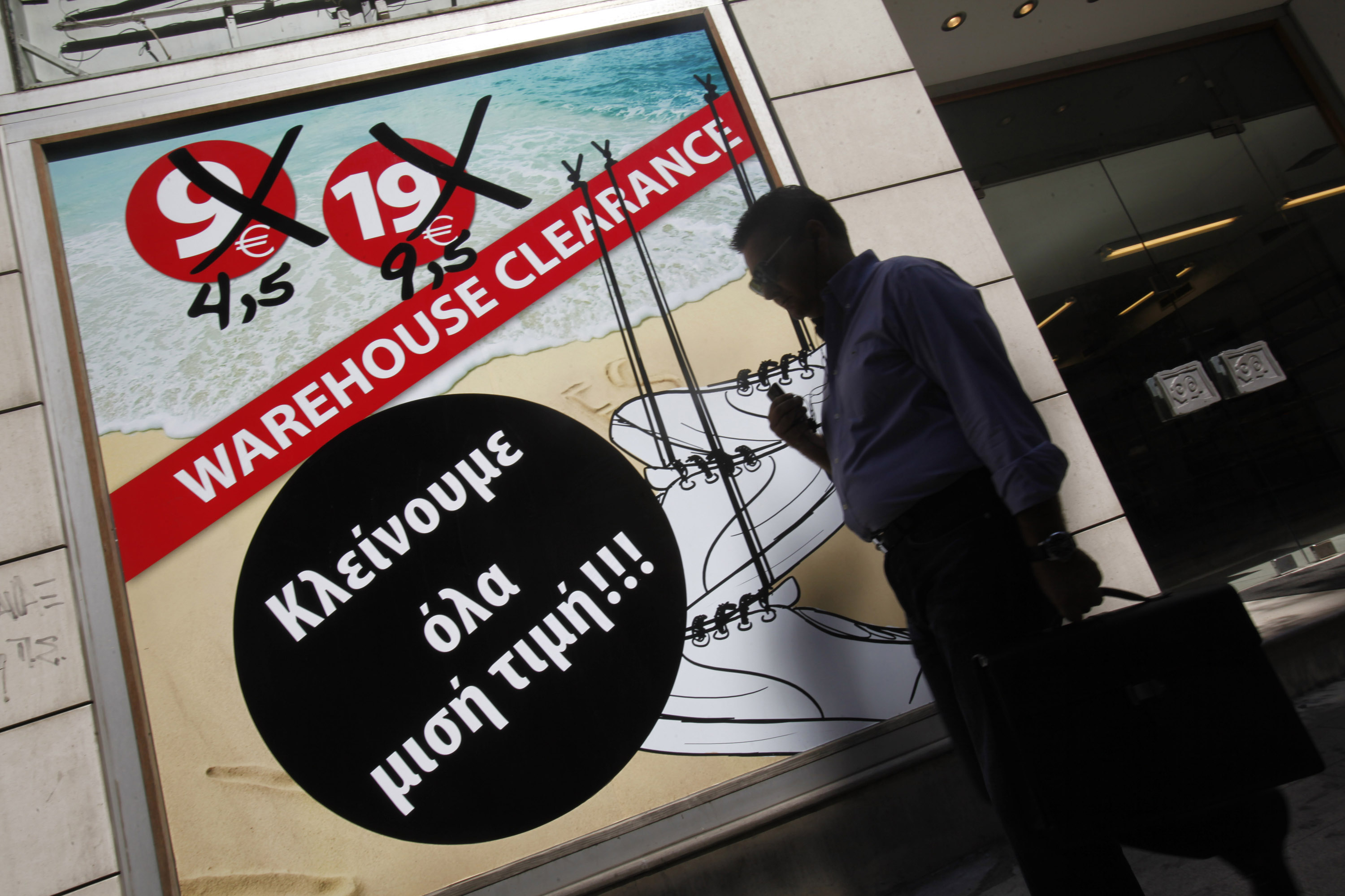 A pedestrian walks past a banner advertising a closing-out sale in Athens. Difficult negotiations between Greece and the eurozone over the country's bailout package could produce unintended consequences. Photo: Bloomberg A pedestrian walks past a banner advertising a closing-out sale in Athens. Difficult negotiations between Greece and the eurozone over the country's bailout package could produce unintended consequences. Photo: Bloomberg