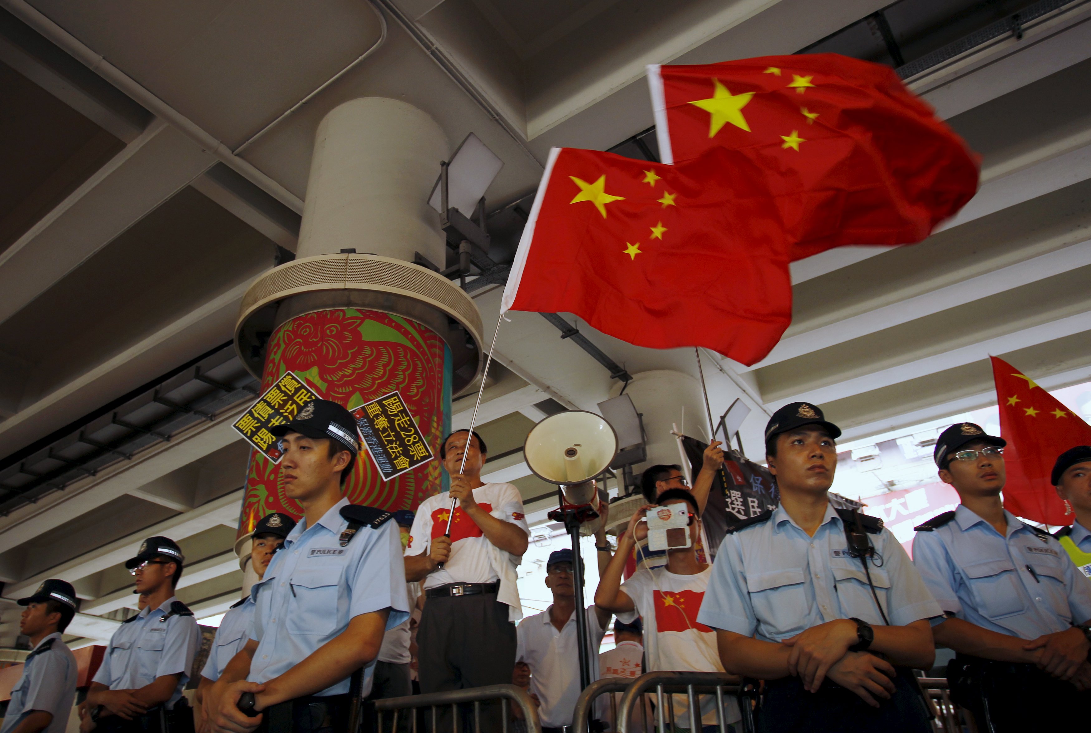 Loyalists wave Chinese national flags at an event marking the Hong Kong handover anniversary. China's new national security law does not apply in Hong Kong but some residents fear arrest if they enter the mainland. Photo: Reuters Loyalists wave Chinese national flags at an event marking the Hong Kong handover anniversary. China's new national security law does not apply in Hong Kong but some residents fear arrest if they enter the mainland. Photo: Reuters