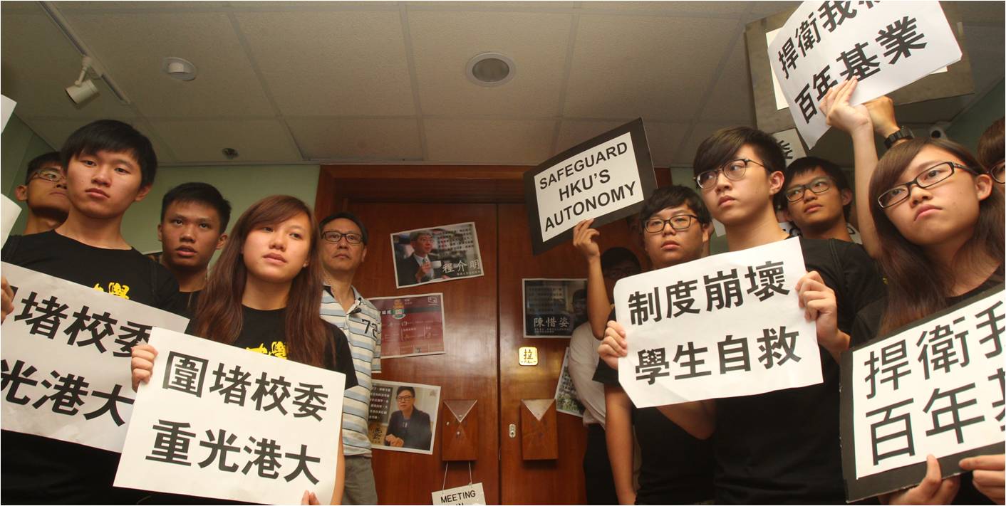 HKU students hold placards demanding academic freedom before a council meeting ended in chaos Tuesday. Photo: HKEJ HKU students hold placards demanding academic freedom before a council meeting ended in chaos Tuesday. Photo: HKEJ
