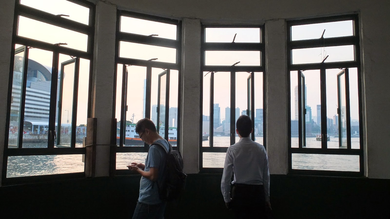 Passengers gaze at Victoria Harbor from behind the windows while waiting for their ferry ride. Photo: Bamboo 竹仔 Passengers gaze at Victoria Harbor from behind the windows while waiting for their ferry ride. Photo: Bamboo 竹仔