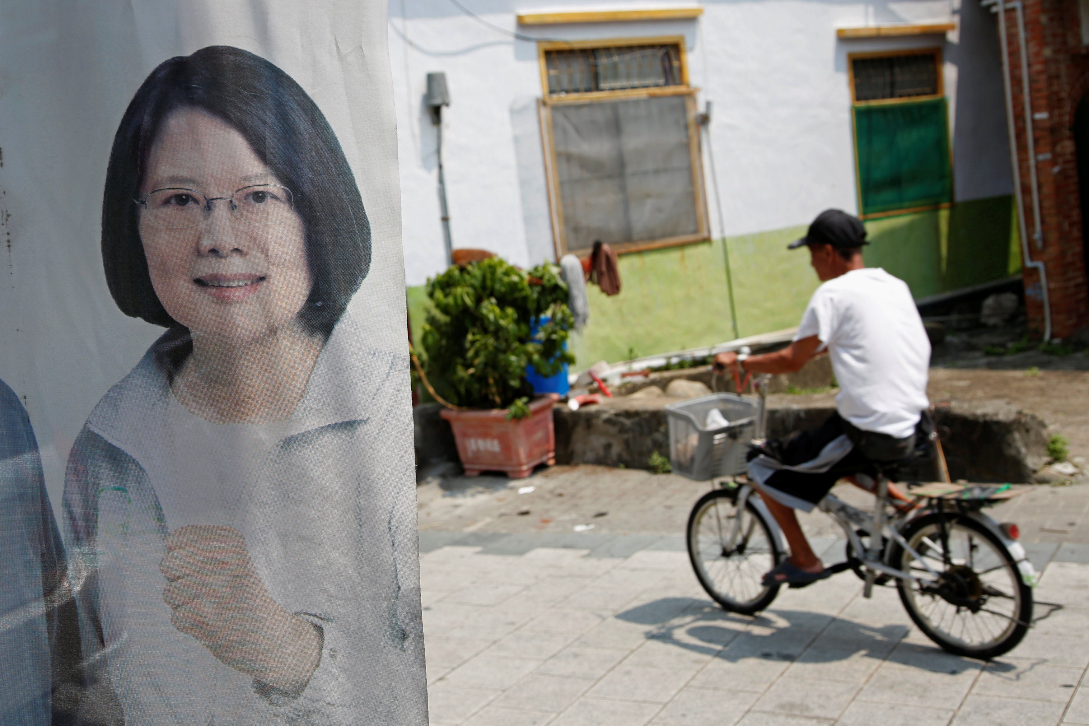 A man rides a bicycle past an election poster of Taiwan president-elect Tsai Ing-wen. Tsai won 56 percent of the vote in January on the back of popular disenchant over the ecoomy. Photo: Reuters A man rides a bicycle past an election poster of Taiwan president-elect Tsai Ing-wen. Tsai won 56 percent of the vote in January on the back of popular disenchant over the ecoomy. Photo: Reuters