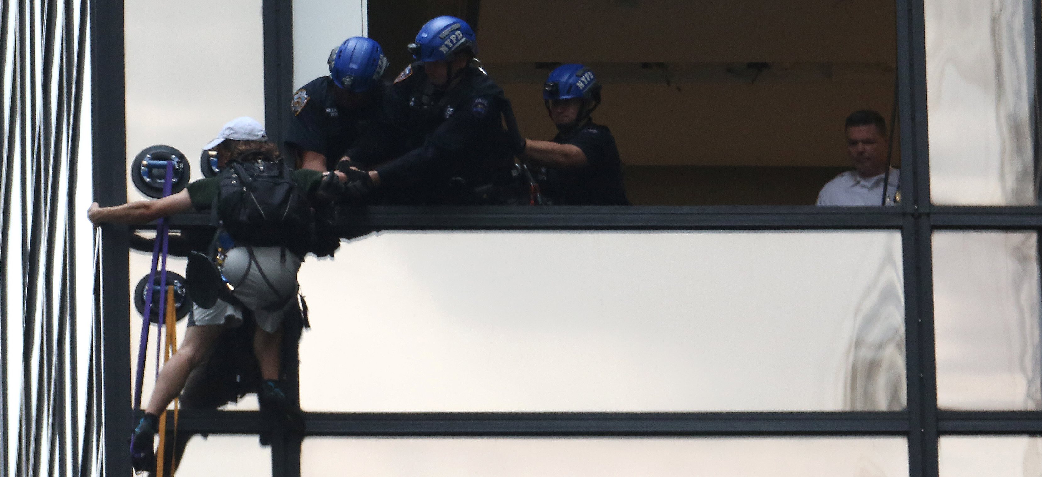 Policemen prepare to pull a climber into a window of Trump Tower in the Manhattan borough of New York. The man said he was seeking a meeting with Donald Trump. Photo: Reuters Policemen prepare to pull a climber into a window of Trump Tower in the Manhattan borough of New York. The man said he was seeking a meeting with Donald Trump. Photo: Reuters