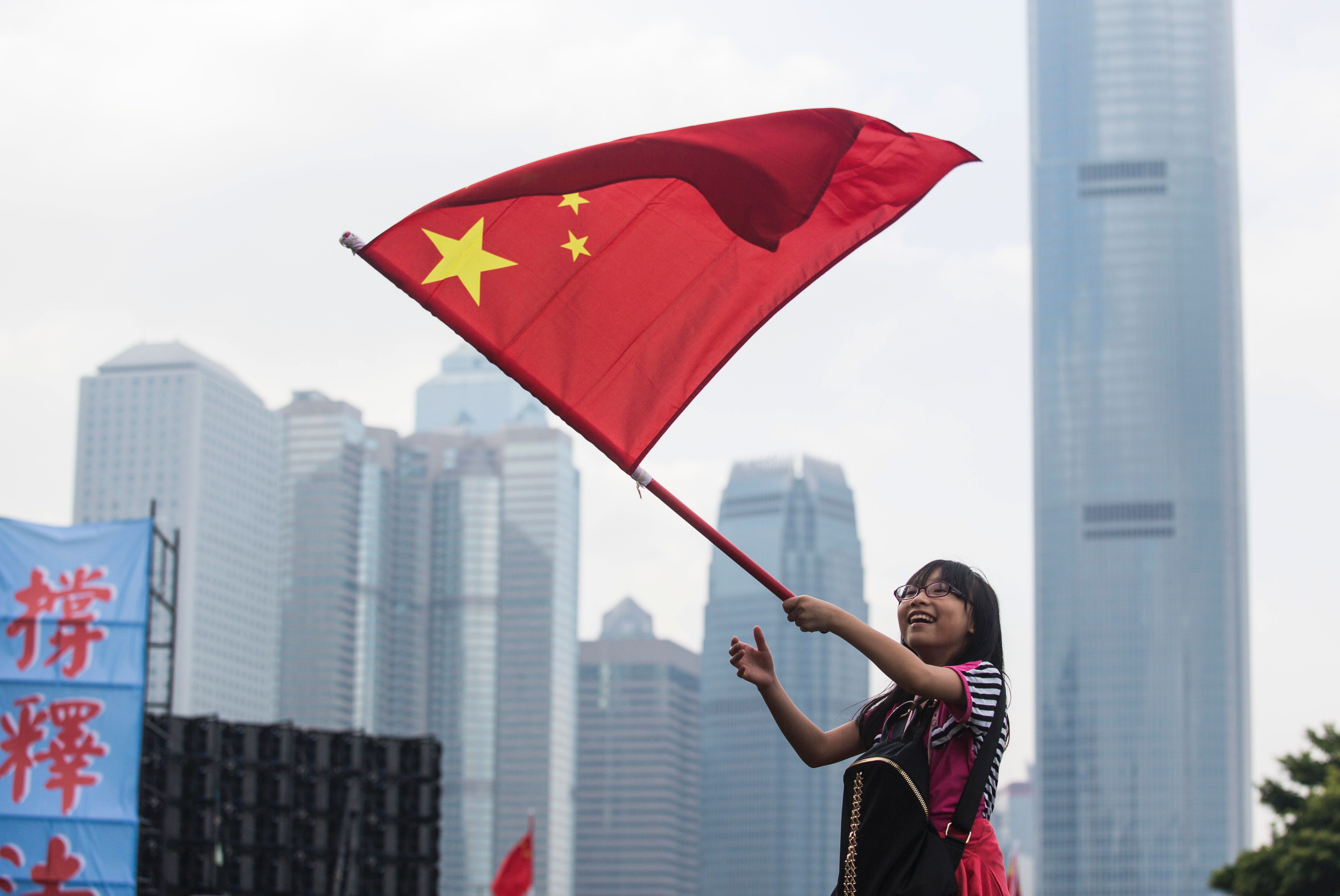 A young girl waves the Chinese flag during a rally in support of an interpretation of the Hong Kong constitution by China's National People's Congress. Photo: AFP A young girl waves the Chinese flag during a rally in support of an interpretation of the Hong Kong constitution by China's National People's Congress. Photo: AFP