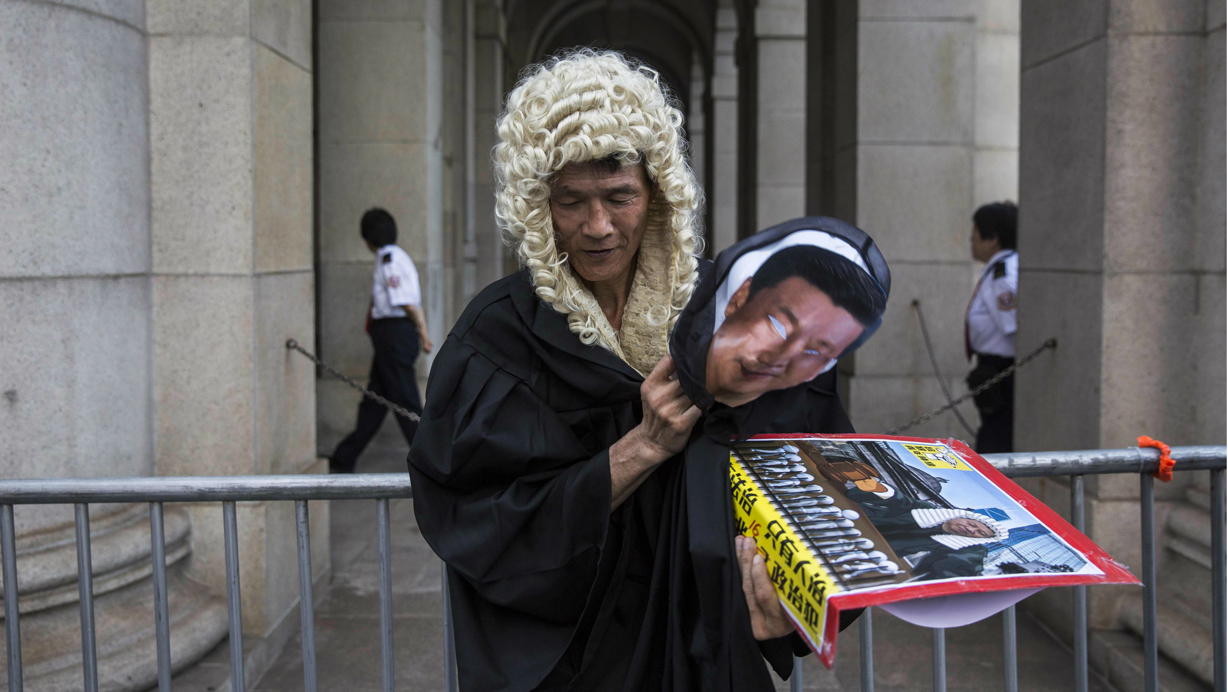 A protester dressed as a judge and holding a mask of Chinese President Xi Jinping stands outside the Court of Final Appeal during a protest against the jailing of pro-democracy activists on Sunday. Photo: AFP A protester dressed as a judge and holding a mask of Chinese President Xi Jinping stands outside the Court of Final Appeal during a protest against the jailing of pro-democracy activists on Sunday. Photo: AFP