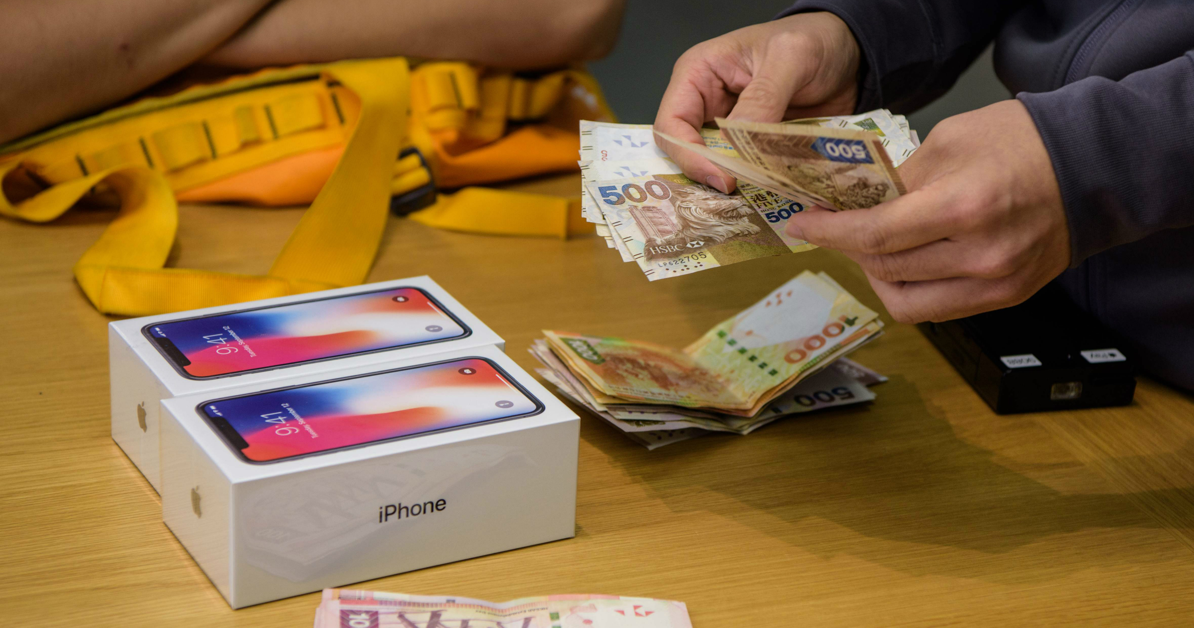 A store clerk counts cash payments for two iPhone X sets. Apple will slash its sales forecast for the iPhone X in the quarter to 30 million units, Taiwan’s Economic Daily reported. Photo: AFP A store clerk counts cash payments for two iPhone X sets. Apple will slash its sales forecast for the iPhone X in the quarter to 30 million units, Taiwan’s Economic Daily reported. Photo: AFP