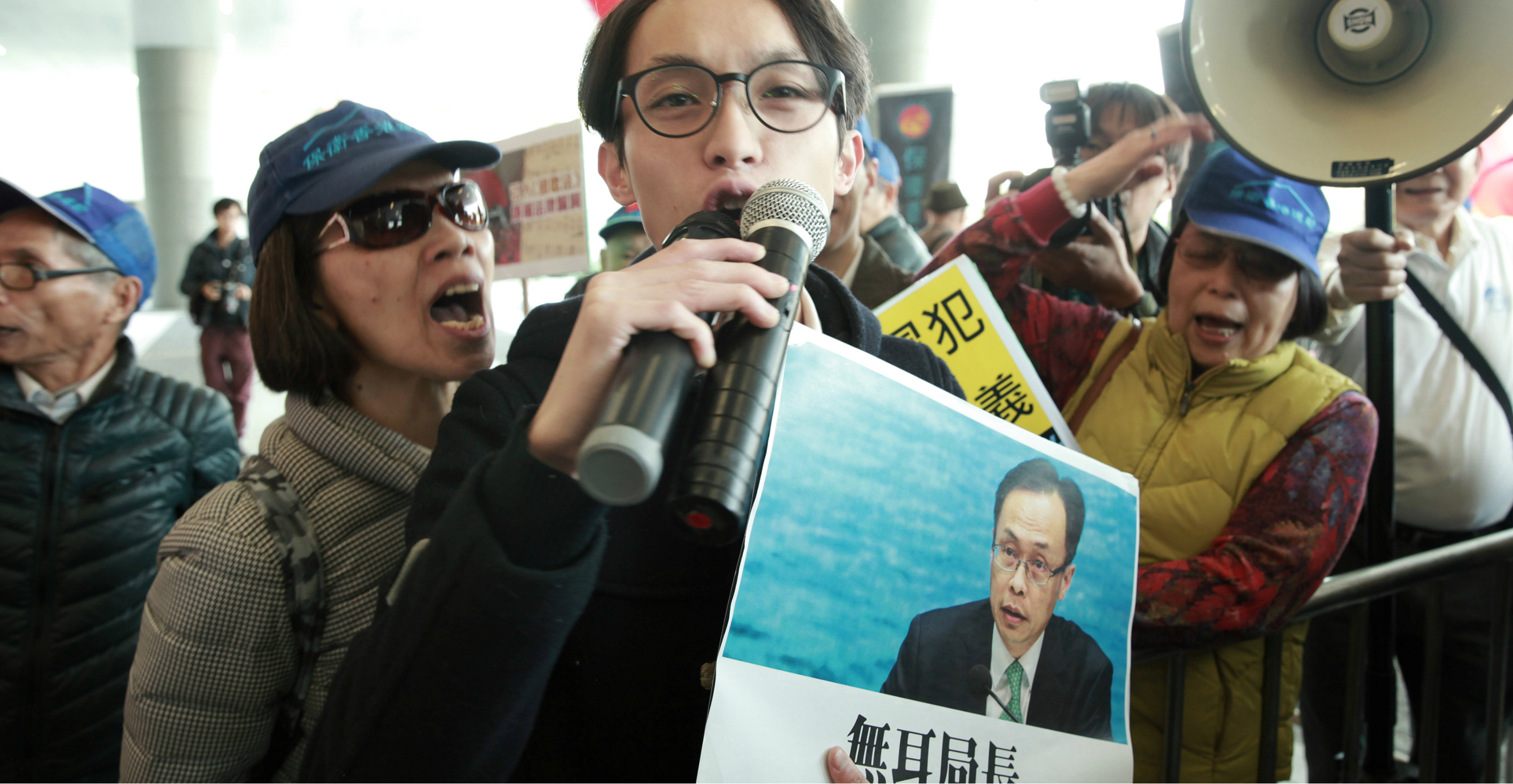 Pro-democracy activist Figo Chan, holding a sign showing Secretary for Constitutional and Mainland Affairs Patrick Nip, clashes with pro-Beijing protesters over the national anthem bill outside the Legislative Council complex on Wednesday. Photo: Reuters Pro-democracy activist Figo Chan, holding a sign showing Secretary for Constitutional and Mainland Affairs Patrick Nip, clashes with pro-Beijing protesters over the national anthem bill outside the Legislative Council complex on Wednesday. Photo: Reuters