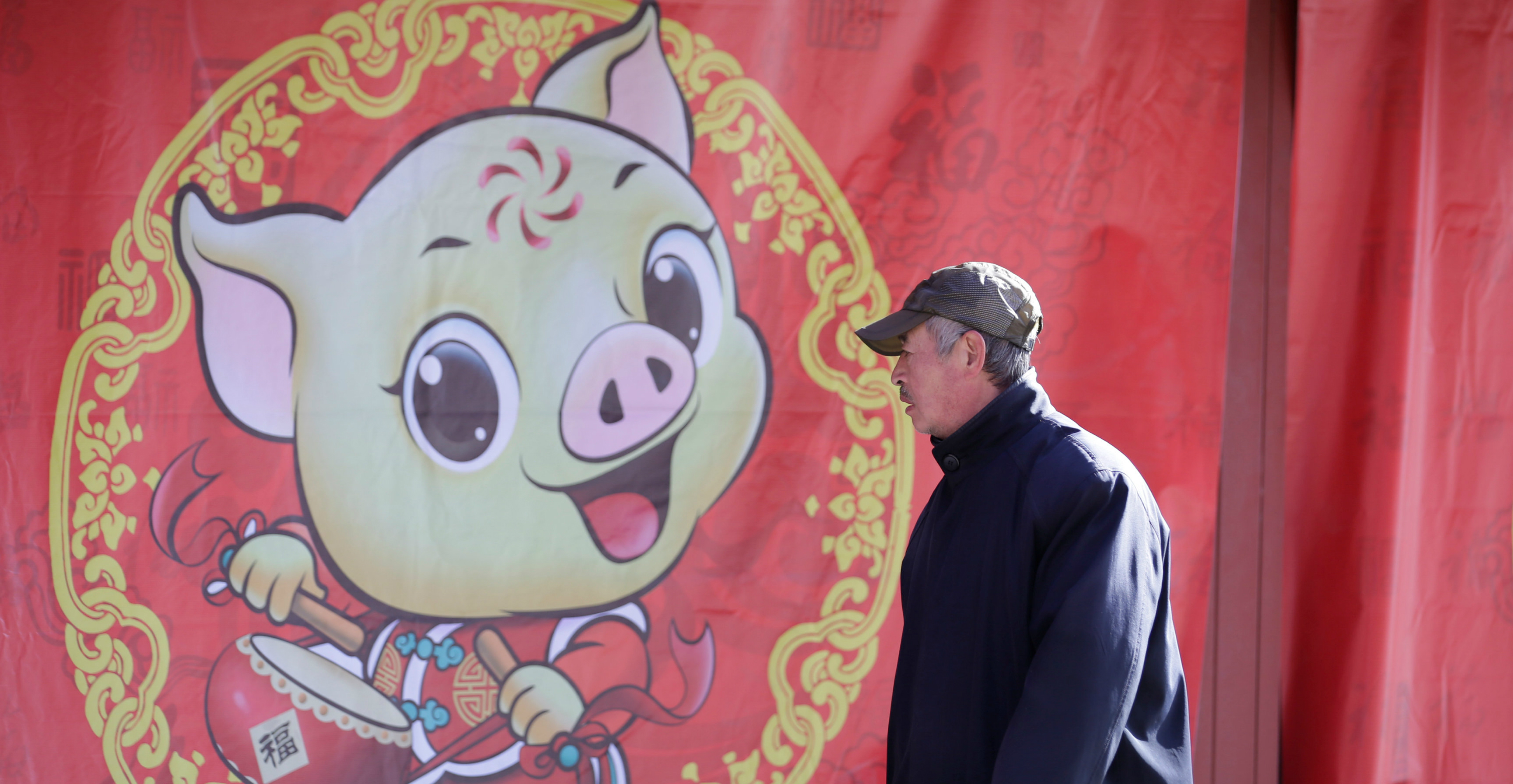 A man walks past a poster celebrating the upcoming Lunar New Year of the Pig at Ditan Park in Beijing on Monday. Photo: Reuters A man walks past a poster celebrating the upcoming Lunar New Year of the Pig at Ditan Park in Beijing on Monday. Photo: Reuters