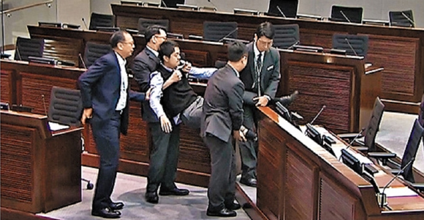 Democratic Party lawmaker Ted Hui is physically removed by security guards from a meeting of the committee on the national anthem bill on Monday. Photo: TVB News Democratic Party lawmaker Ted Hui is physically removed by security guards from a meeting of the committee on the national anthem bill on Monday. Photo: TVB News