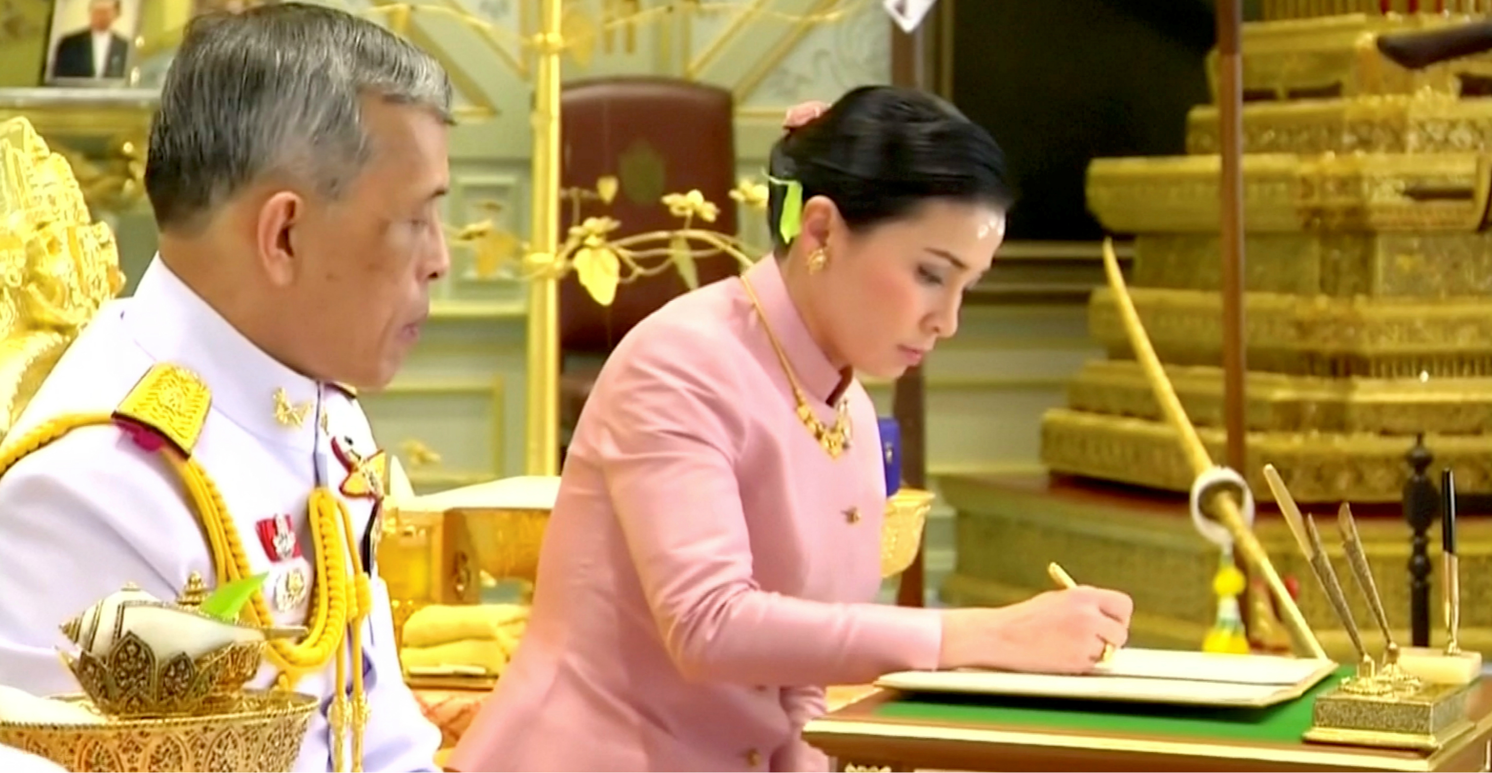 King Maha Vajiralongkorn and his consort, General Suthida Vajiralongkorn named Queen Suthida, sign marriage documents during their wedding ceremony in Bangkok on Wednesday. Photo: Thai TV Pool King Maha Vajiralongkorn and his consort, General Suthida Vajiralongkorn named Queen Suthida, sign marriage documents during their wedding ceremony in Bangkok on Wednesday. Photo: Thai TV Pool