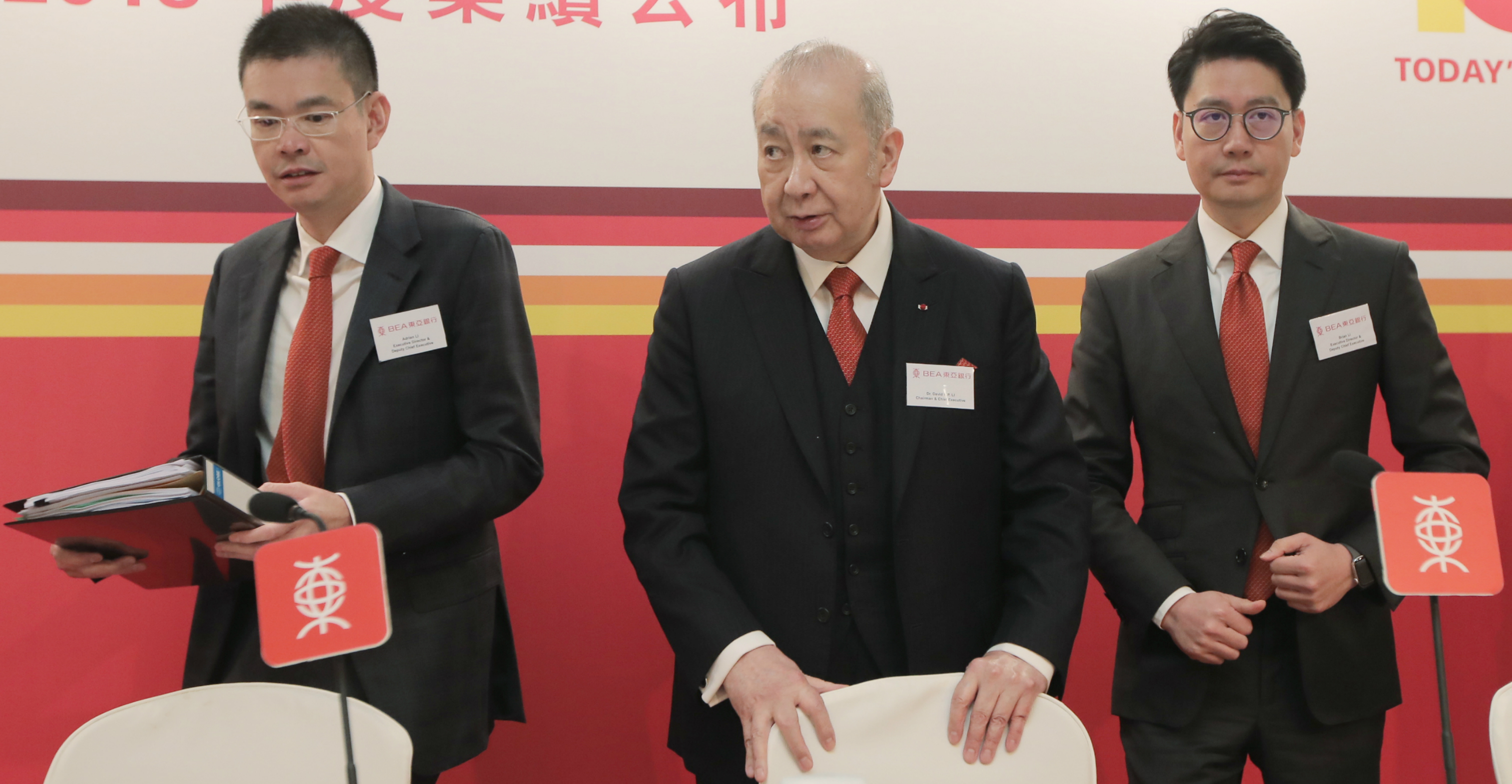 Bank of East Asia chairman and chief executive David Li is flanked by his sons Adrian (left) and Brian during an earnings results announcement in February. Photo: HKEJ Bank of East Asia chairman and chief executive David Li is flanked by his sons Adrian (left) and Brian during an earnings results announcement in February. Photo: HKEJ