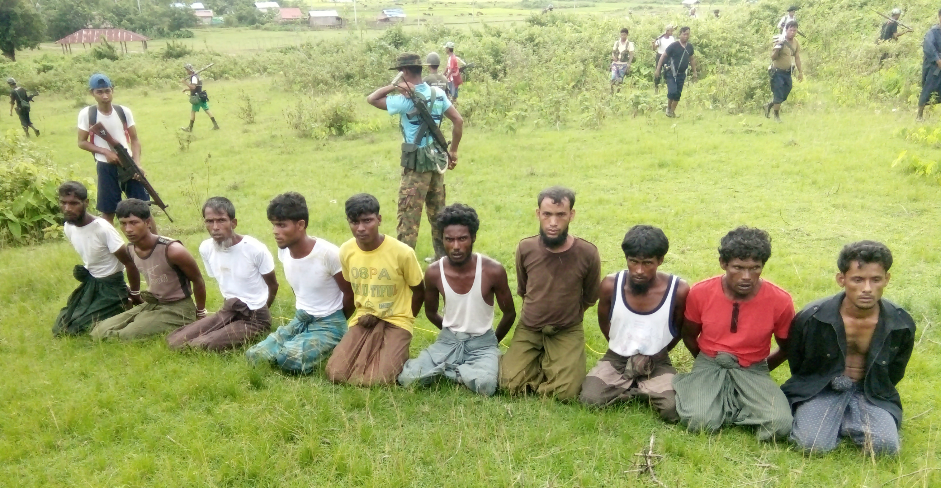 Ten Rohingya men with their hands bound kneel as members of the Myanmar security forces stand guard in Inn Din village of Rakhine State, Myanmar, on Sept. 2, 2017. Photo: Handout via Reuters Ten Rohingya men with their hands bound kneel as members of the Myanmar security forces stand guard in Inn Din village of Rakhine State, Myanmar, on Sept. 2, 2017. Photo: Handout via Reuters