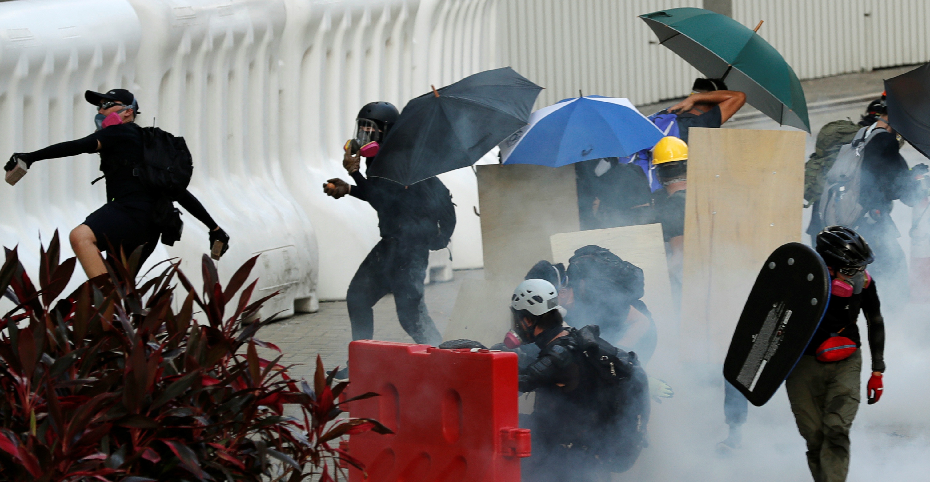 Protesters hurl objects at the police after tear gas was fired to disperse a demonstration in support of Monday's general strike. Photo: Reuters Protesters hurl objects at the police after tear gas was fired to disperse a demonstration in support of Monday's general strike. Photo: Reuters