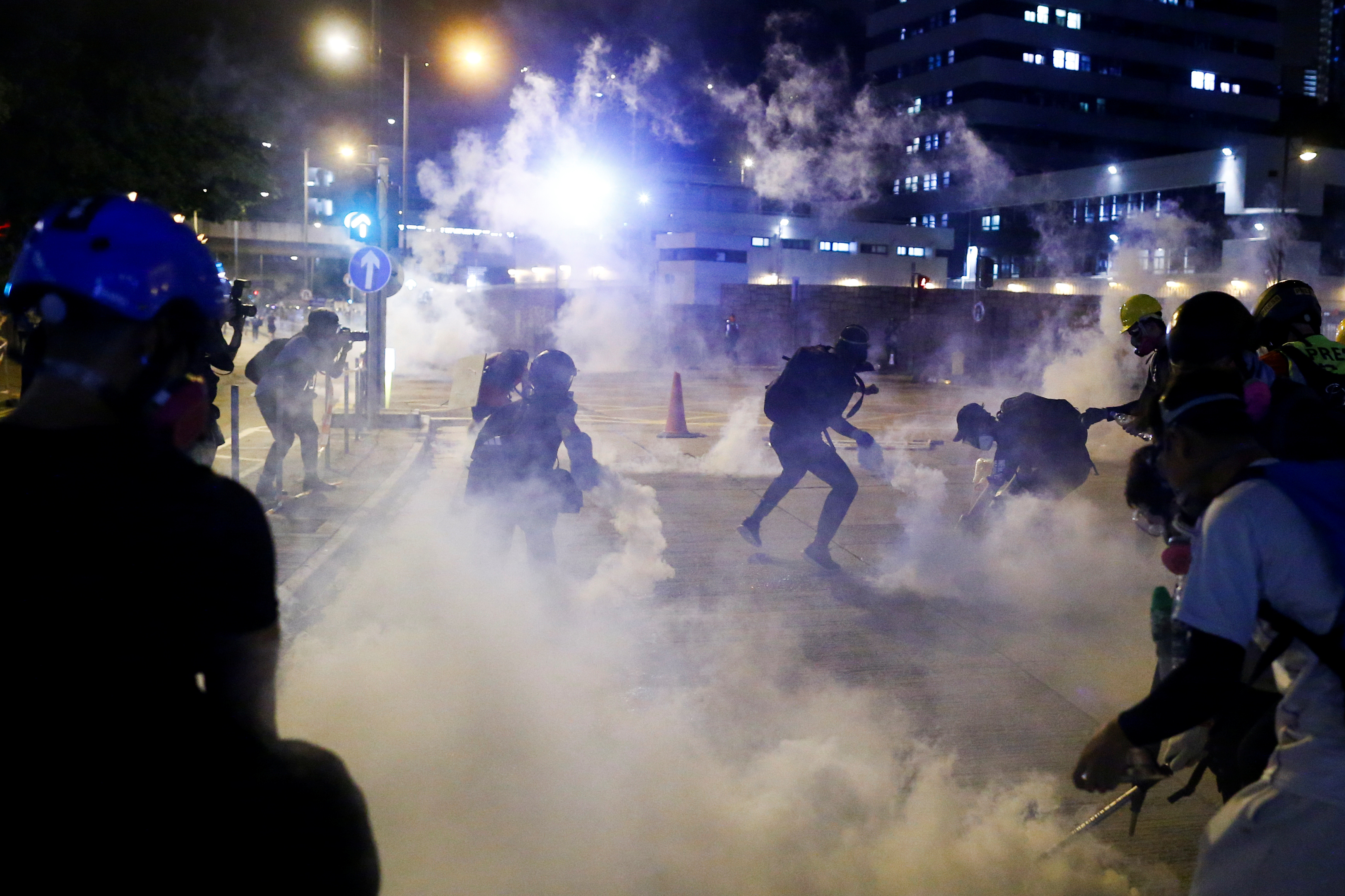 Anti-government protesters throw tear gas back at police during clashes outside the police station in Kwai Fong in Hong Kong on Sunday. Photo: Reuters Anti-government protesters throw tear gas back at police during clashes outside the police station in Kwai Fong in Hong Kong on Sunday. Photo: Reuters