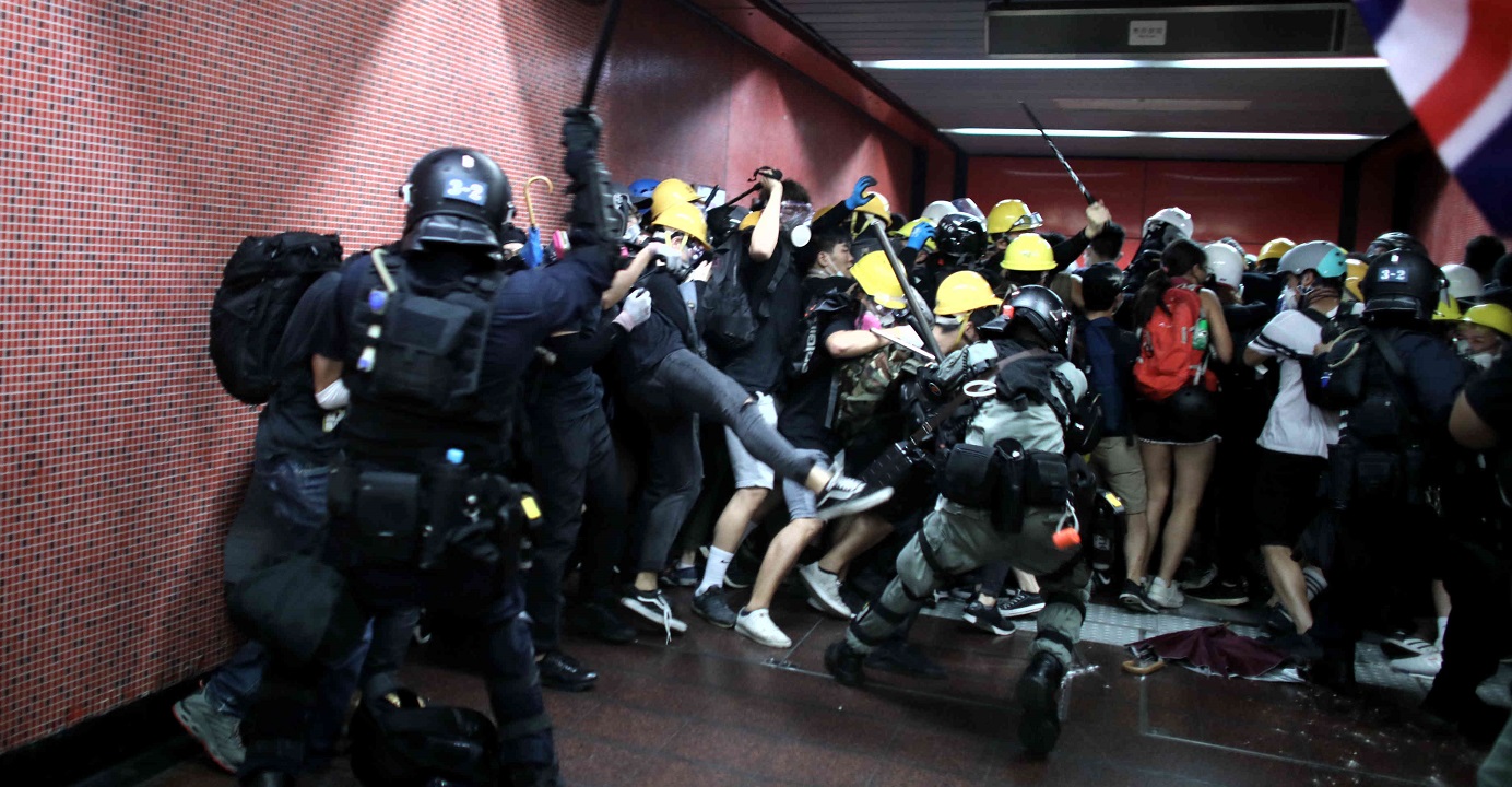 At an exit of Tai Koo MTR Station, riot police with truncheons chased protesters into the station. Photo: HKEJ At an exit of Tai Koo MTR Station, riot police with truncheons chased protesters into the station. Photo: HKEJ