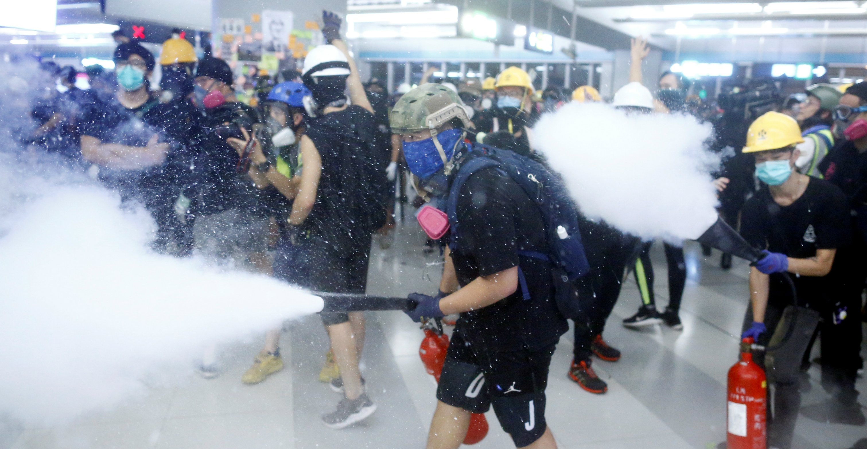 Protesters spray fire extinguishers inside the Yuen Long MTR Station on Wednesday. Photo: Reuters Protesters spray fire extinguishers inside the Yuen Long MTR Station on Wednesday. Photo: Reuters