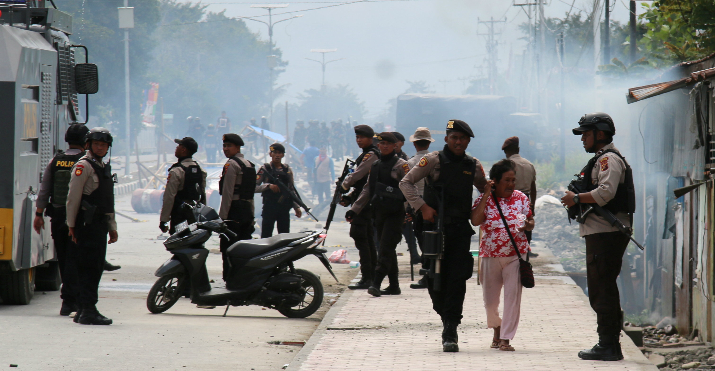 A police officer escorts a woman during a protest in Mimika, Papua, on Wednesday. Photo: Antara Foto via Reuters A police officer escorts a woman during a protest in Mimika, Papua, on Wednesday. Photo: Antara Foto via Reuters