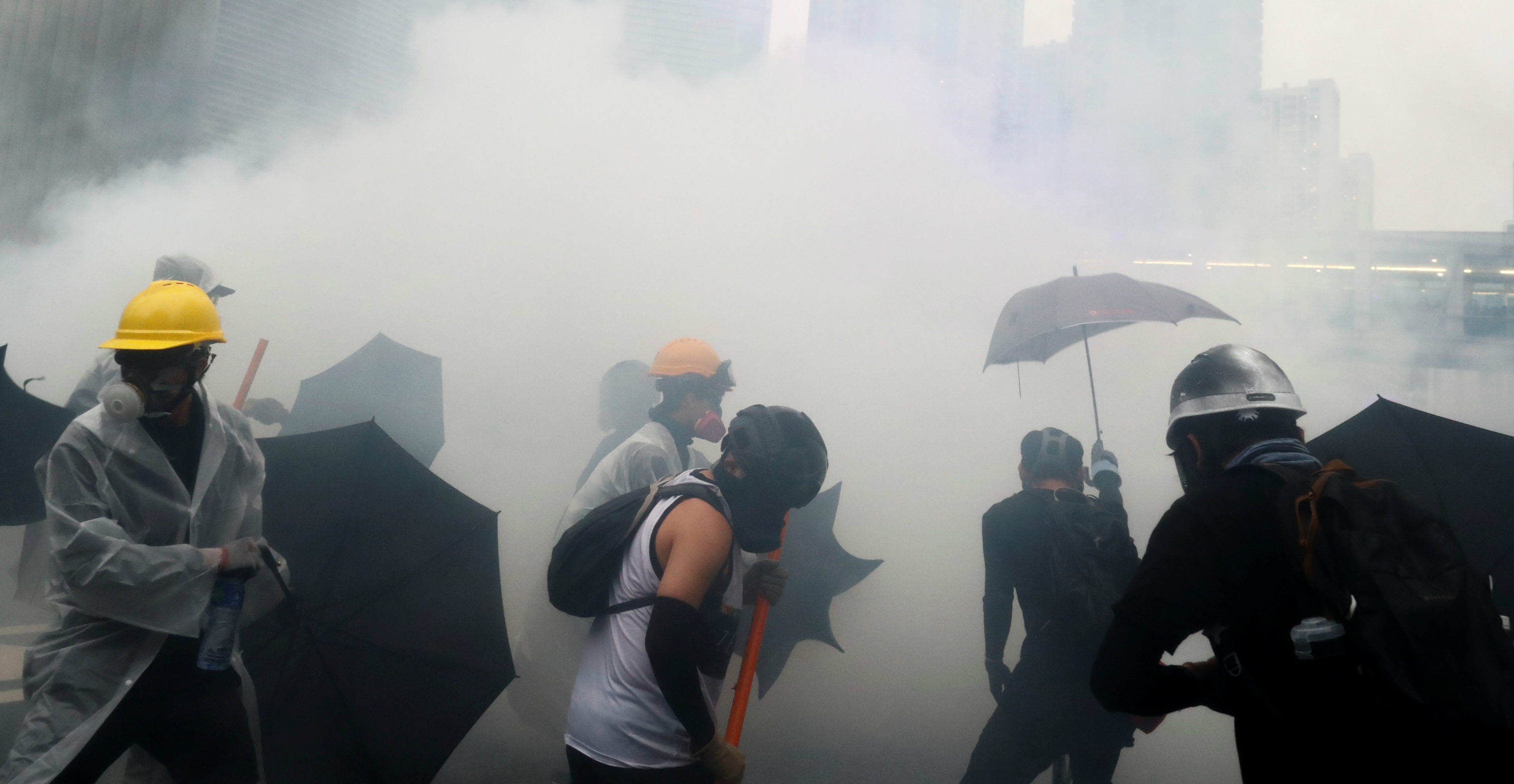 Protesters take cover from tear gas during clashes with police in Tsuen Wan on Sunday. Photo: Reuters Protesters take cover from tear gas during clashes with police in Tsuen Wan on Sunday. Photo: Reuters