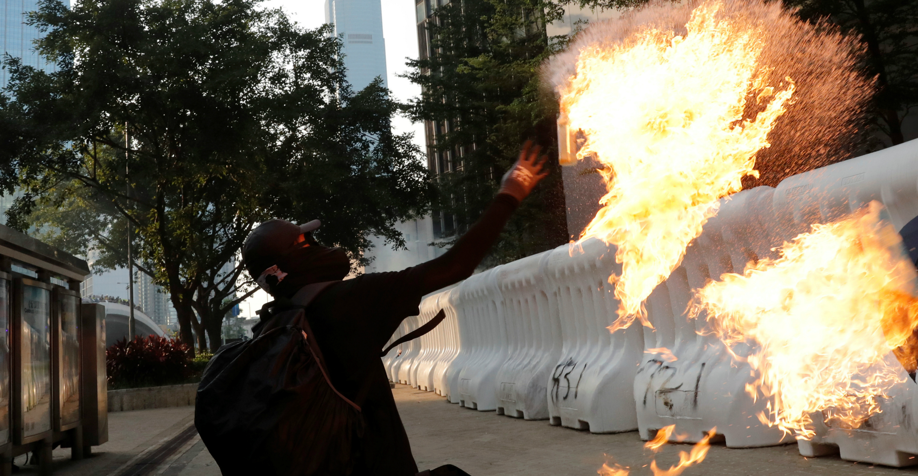 A protester throws a Molotov cocktail near the government headquarters in Admiralty on Sunday. Photo: Reuters A protester throws a Molotov cocktail near the government headquarters in Admiralty on Sunday. Photo: Reuters