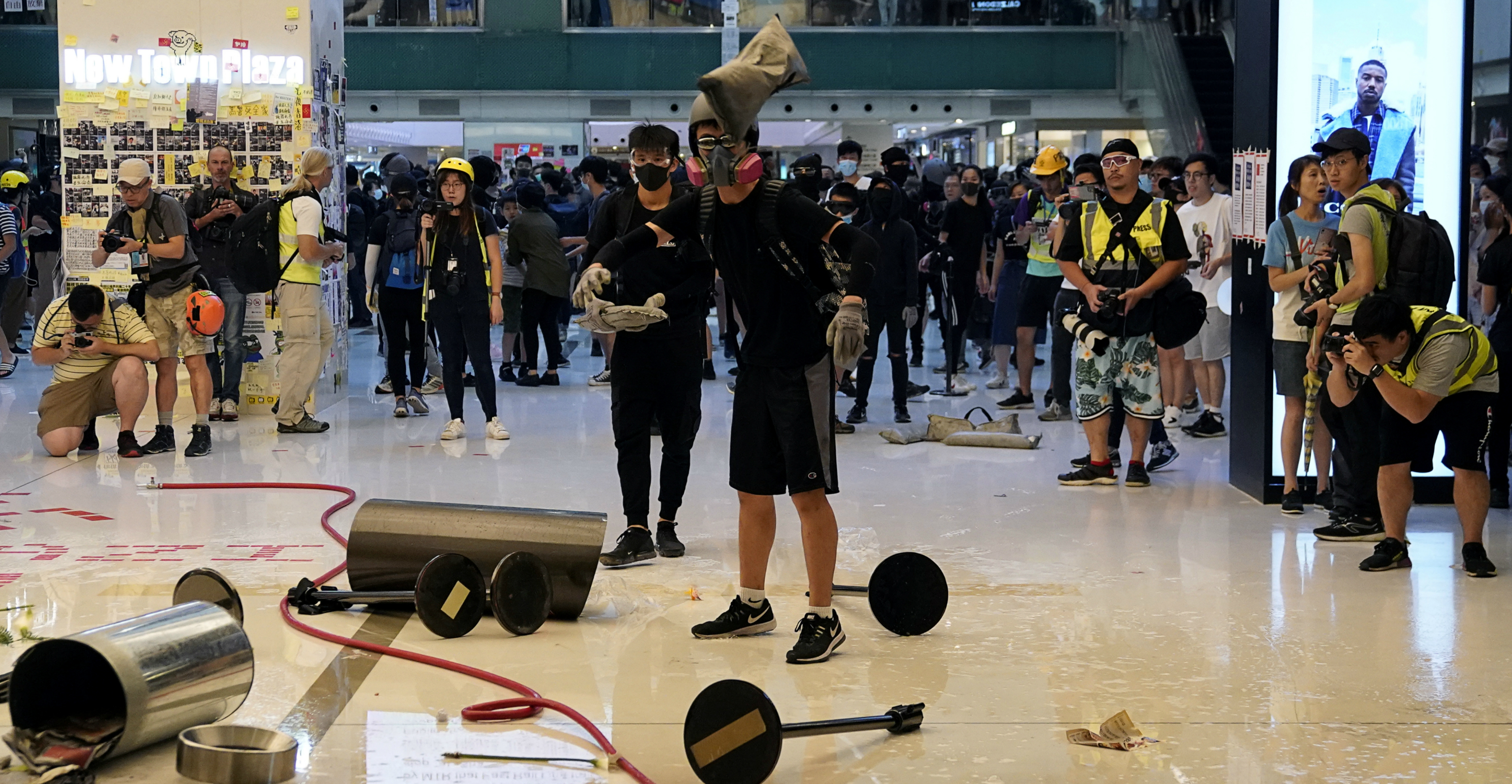 Anti-government protesters throw items at New Town Plaza in Sha Tin on Sunday. Photo: Reuters Anti-government protesters throw items at New Town Plaza in Sha Tin on Sunday. Photo: Reuters