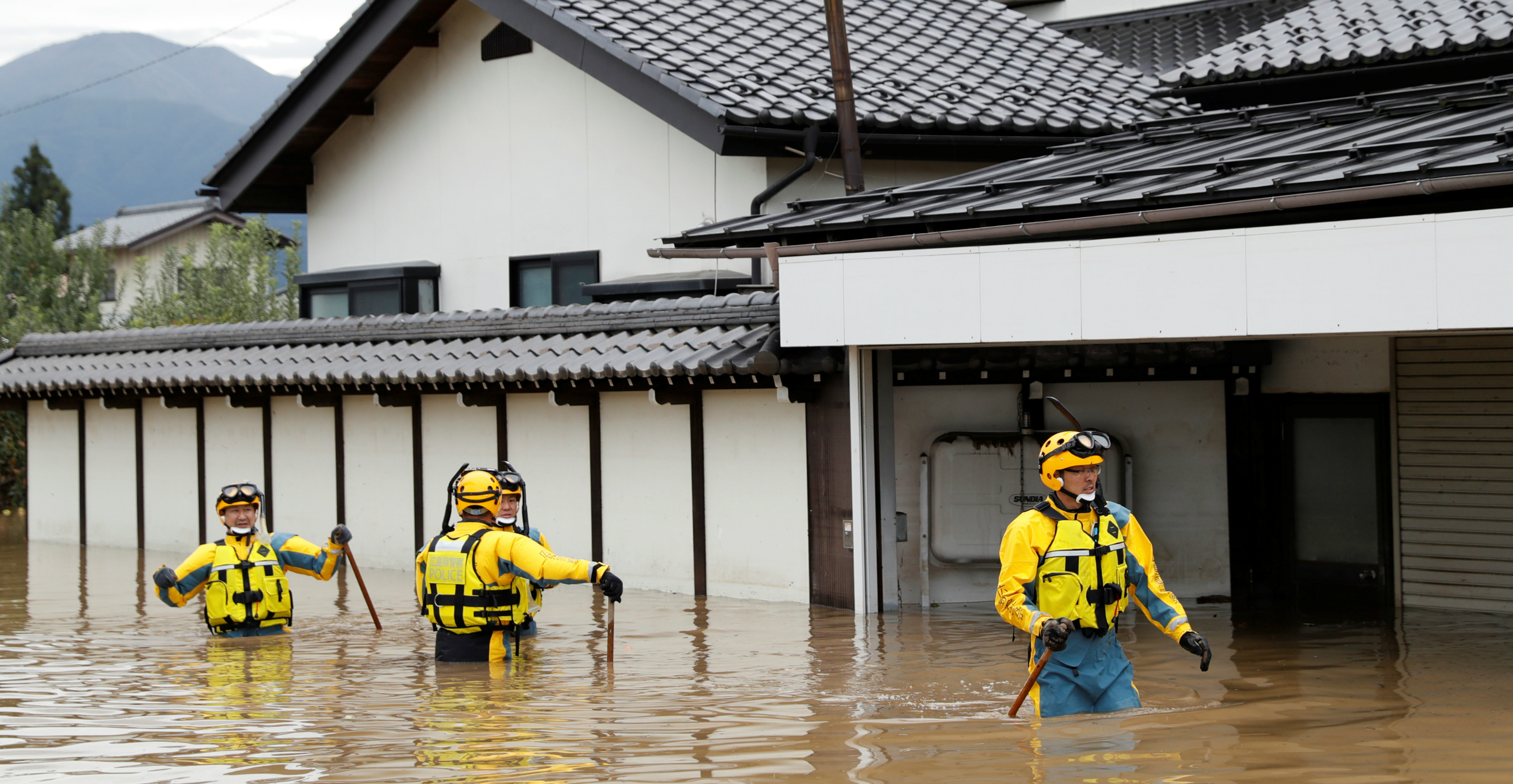 Police wade through a flooded area in the aftermath of Typhoon Hagibis, which caused severe floods at the Chikuma River in Nagano Prefecture, Japan, on Monday. Photo: Reuters Police wade through a flooded area in the aftermath of Typhoon Hagibis, which caused severe floods at the Chikuma River in Nagano Prefecture, Japan, on Monday. Photo: Reuters