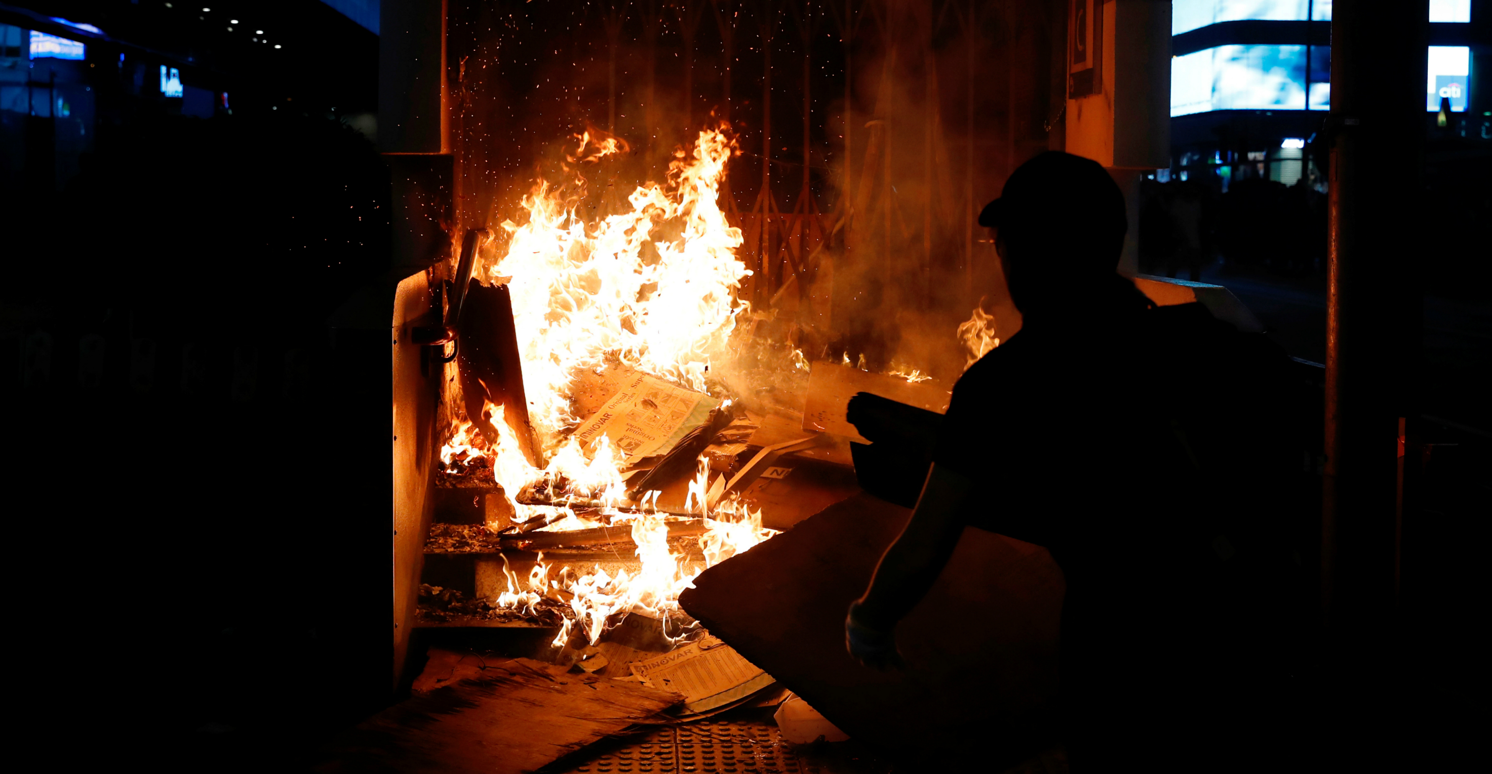 An anti-government protester sets a fire outside the Mong Kok MTR Station on Oct. 4. Photo: Reuters An anti-government protester sets a fire outside the Mong Kok MTR Station on Oct. 4. Photo: Reuters