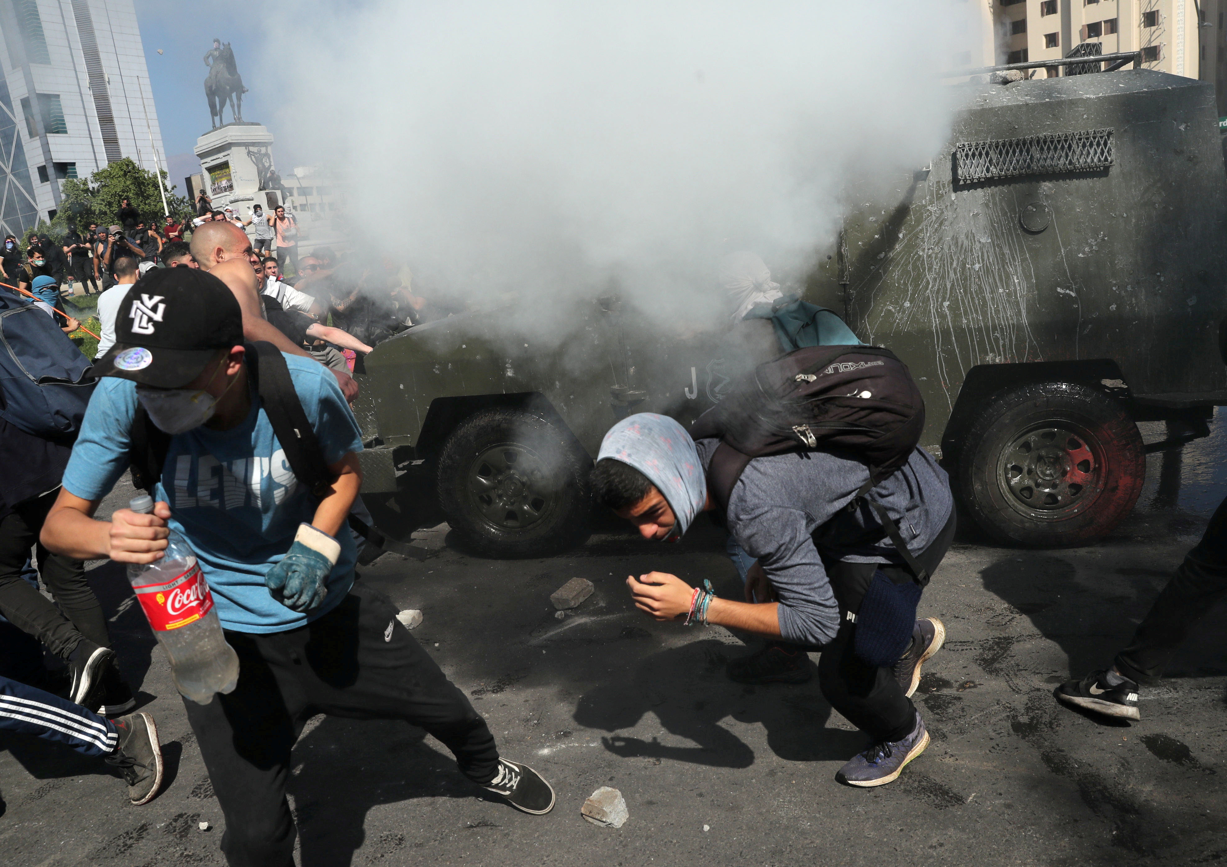 Protesters flee from tear gas during a demonstration in Santiago, Chile, on Sunday. Photo: Reuters Protesters flee from tear gas during a demonstration in Santiago, Chile, on Sunday. Photo: Reuters