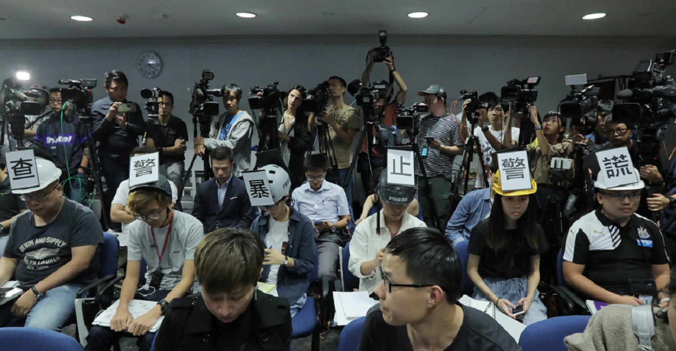 Six reporters stage a silent protest at the start of a regular police press briefing on Monday. Photo: HKEJ Six reporters stage a silent protest at the start of a regular police press briefing on Monday. Photo: HKEJ