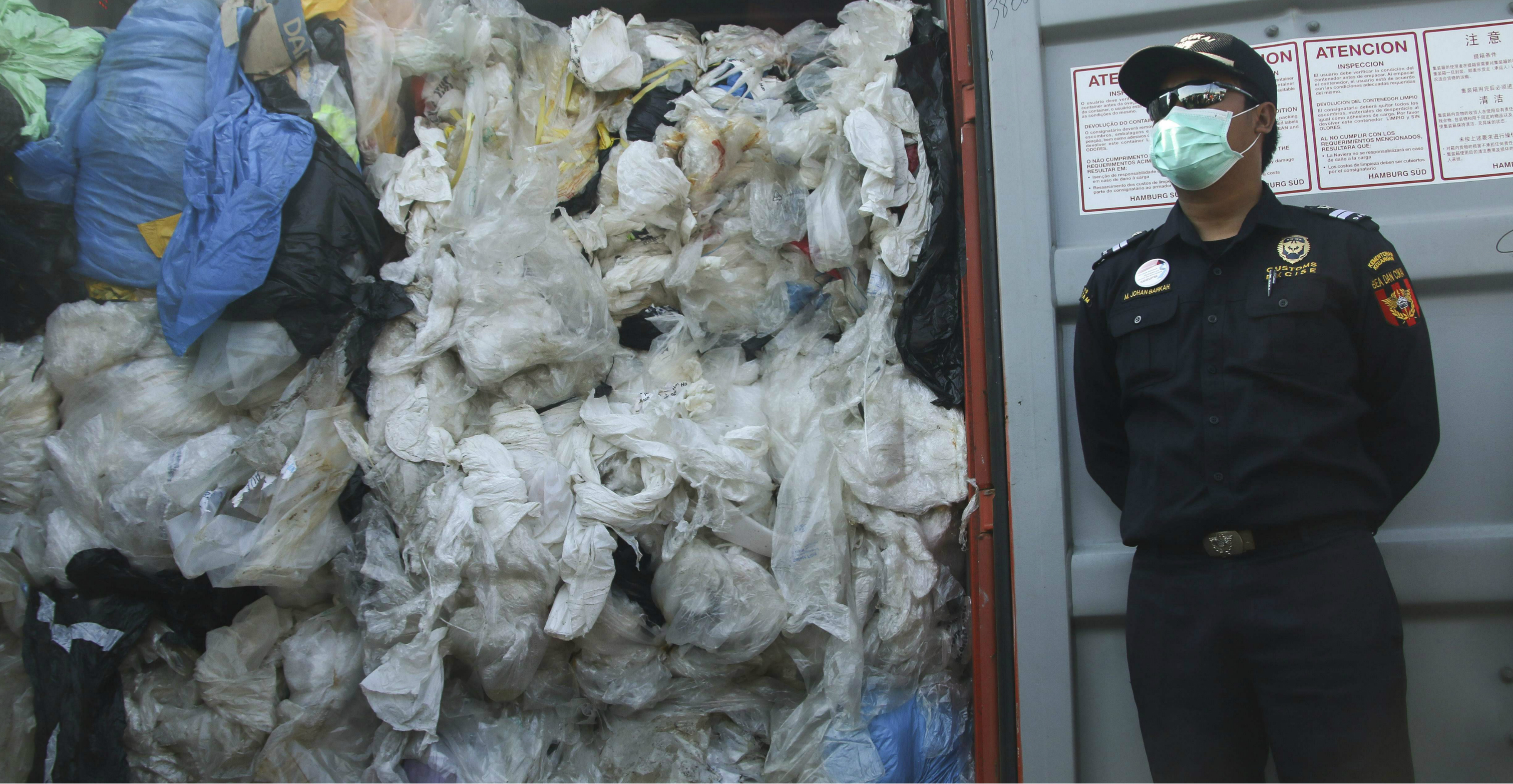 An officer stands next to a container filled with illegally imported plastic waste on Batam island, Indonesia, on July 29, 2019. Photo: AFP An officer stands next to a container filled with illegally imported plastic waste on Batam island, Indonesia, on July 29, 2019. Photo: AFP