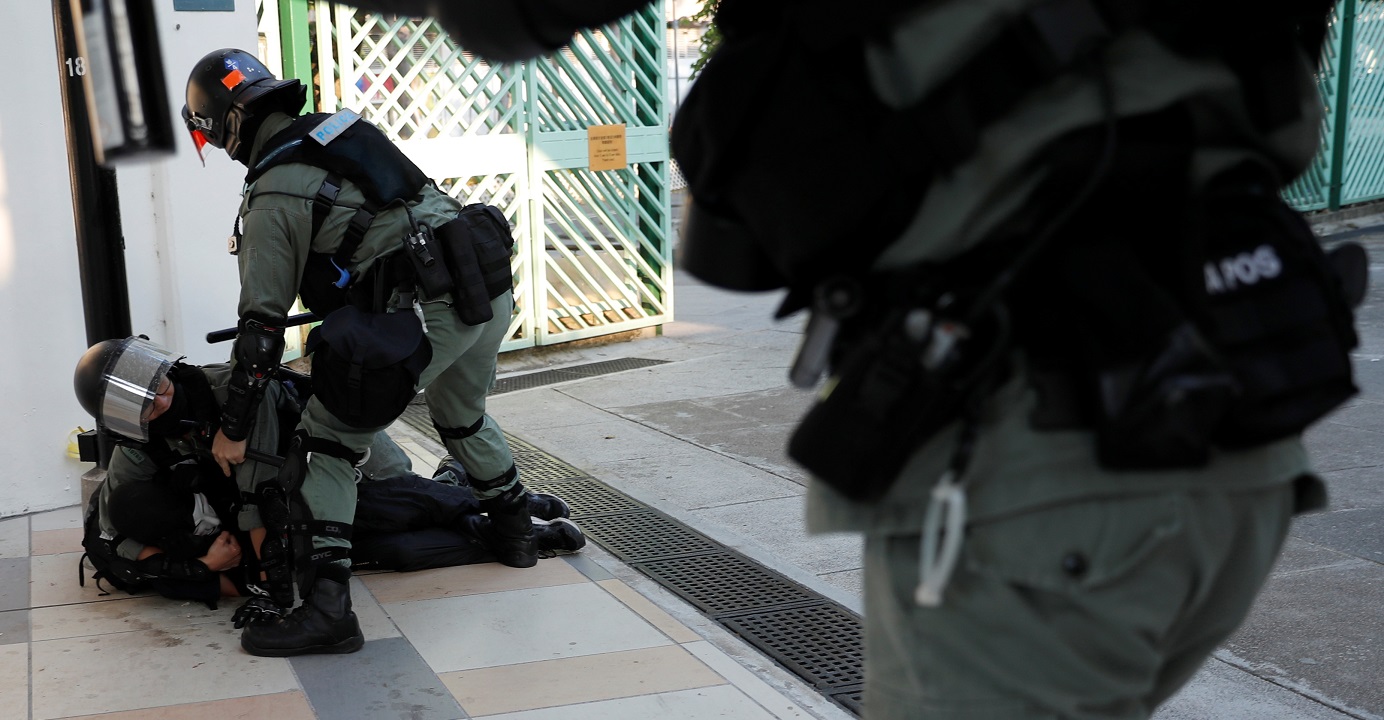 A protester is restrained by riot police officers during an anti-government demonstration in Sha Tin on Sunday. Photo: Reuters A protester is restrained by riot police officers during an anti-government demonstration in Sha Tin on Sunday. Photo: Reuters