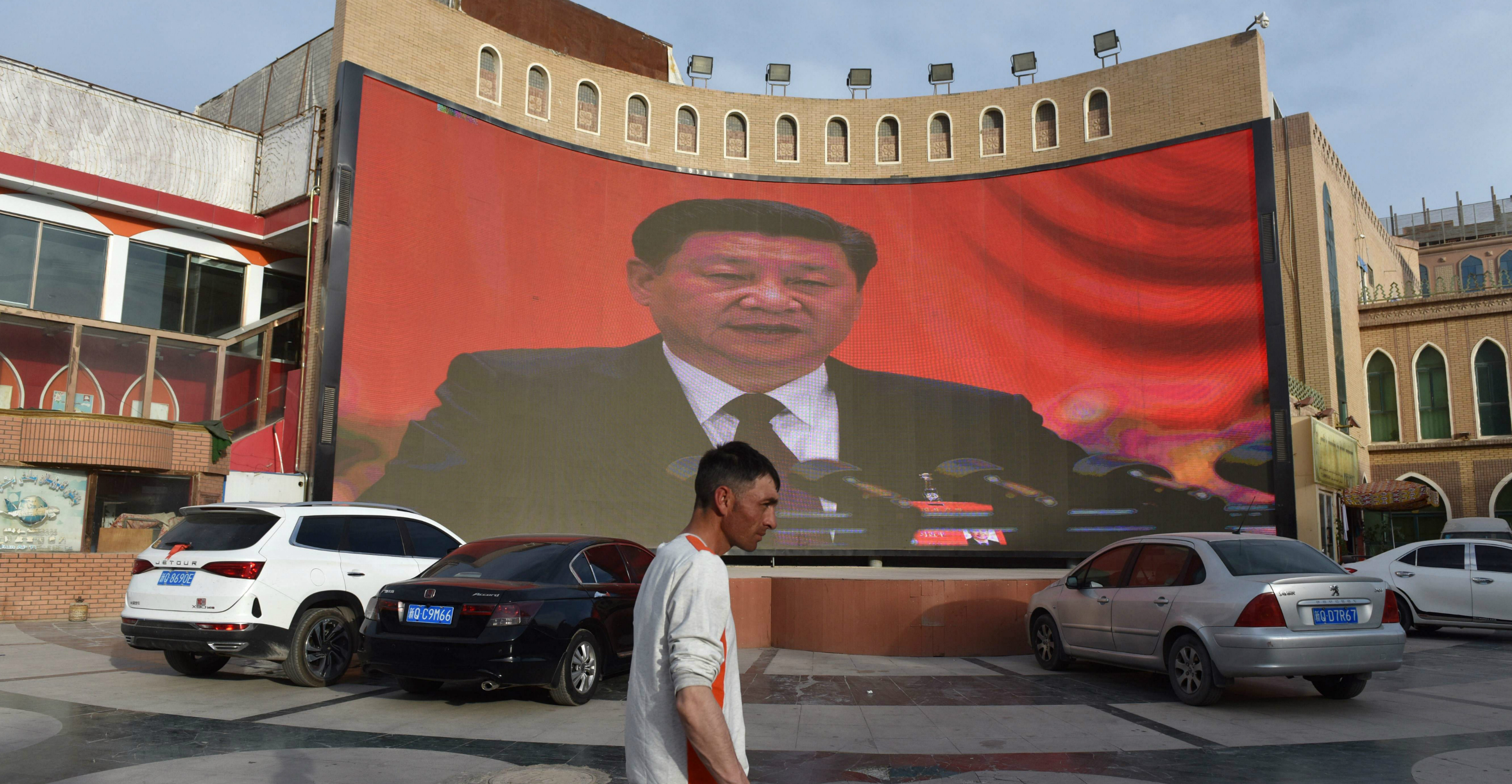 File picture of a man walking past a screen showing images of President Xi Jinping in Kashgar in China's northwest Xinjiang region. Photo: AFP File picture of a man walking past a screen showing images of President Xi Jinping in Kashgar in China's northwest Xinjiang region. Photo: AFP
