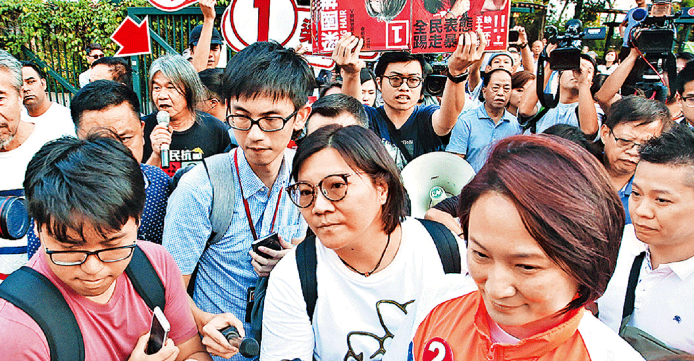 Starry Lee (right, foreground) is confronted by her opponent Leung Kwok-hung (indicated by red arrow) who showed up at her press conference on Sunday afternoon. Photo: HKEJ Starry Lee (right, foreground) is confronted by her opponent Leung Kwok-hung (indicated by red arrow) who showed up at her press conference on Sunday afternoon. Photo: HKEJ