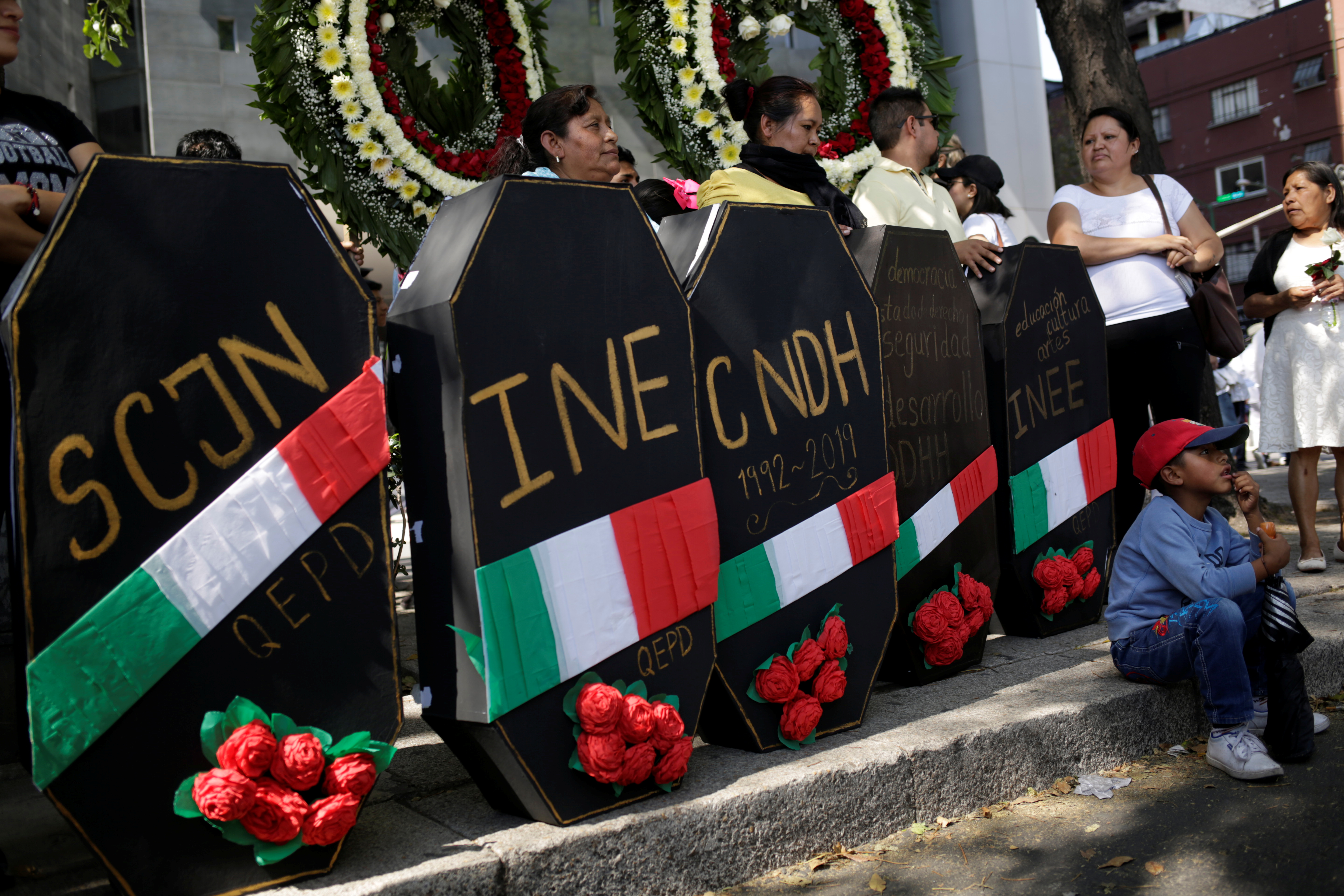 Demonstrators stand next to mock coffins of some government agencies during a march in Mexico City on Sunday to protest against violence, on the first anniversary of President Andres Manuel Lopez Obrador taking office. Photo: Reuters Demonstrators stand next to mock coffins of some government agencies during a march in Mexico City on Sunday to protest against violence, on the first anniversary of President Andres Manuel Lopez Obrador taking office. Photo: Reuters