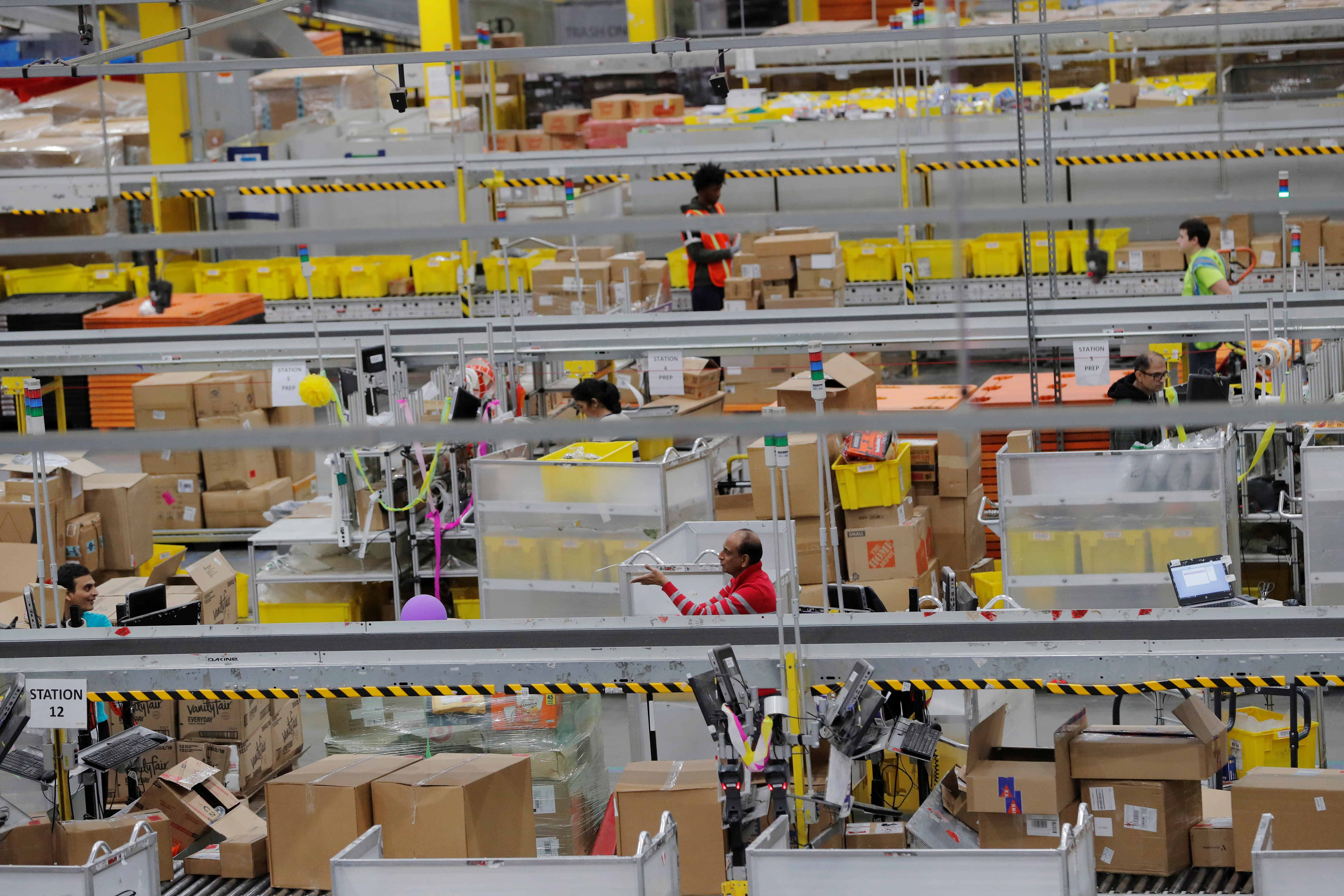 Amazon workers perform their jobs inside a fulfillment center in Robbinsville, New Jersey, on Monday. The company and its rivals have all beefed up services to fulfill online orders more quickly. Photo: Reuters Amazon workers perform their jobs inside a fulfillment center in Robbinsville, New Jersey, on Monday. The company and its rivals have all beefed up services to fulfill online orders more quickly. Photo: Reuters