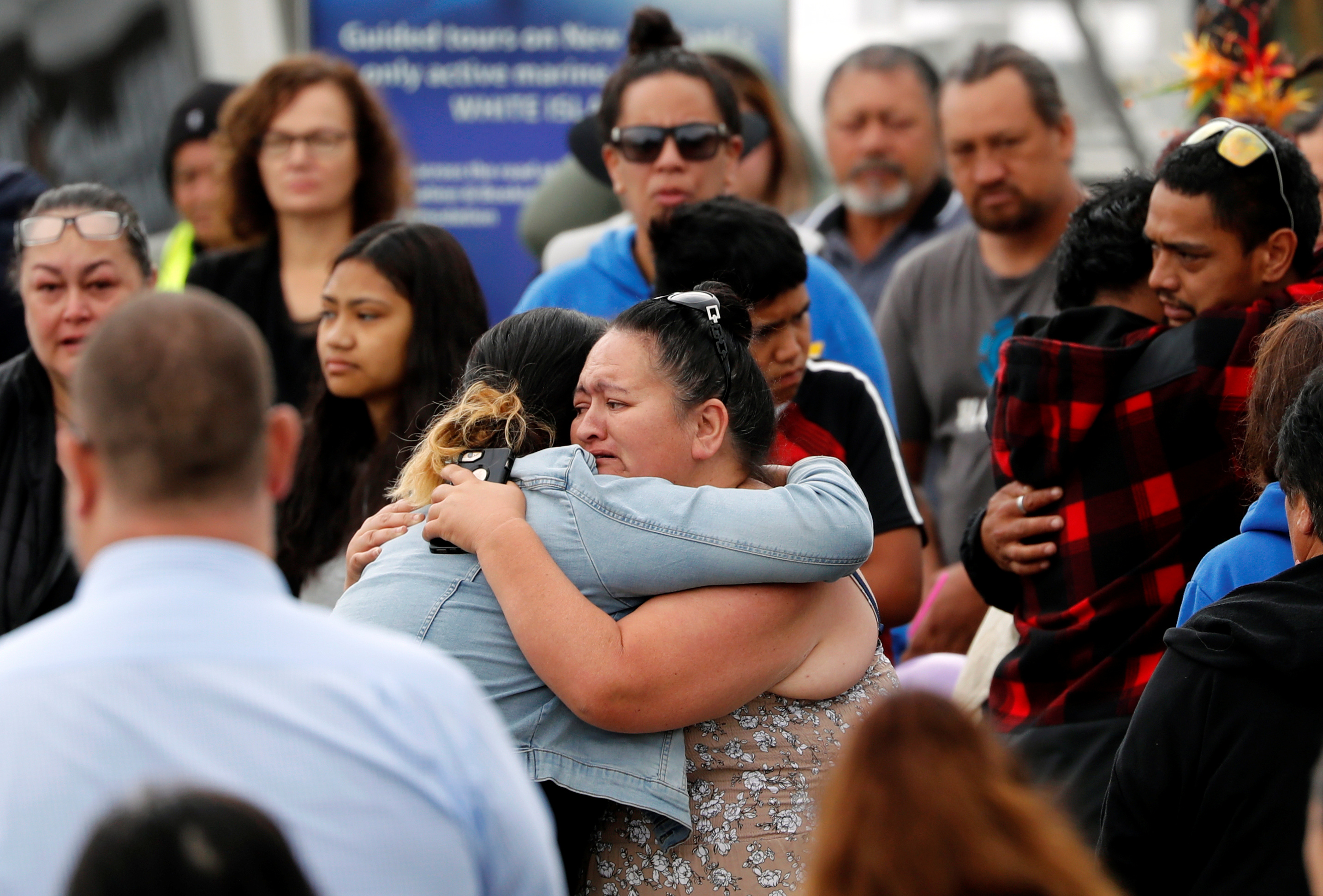 Grieving family members hug each other as they await word from a recovery mission to White Island volcano in Whakatane, New Zealand, on Friday. Photo: Reuters Grieving family members hug each other as they await word from a recovery mission to White Island volcano in Whakatane, New Zealand, on Friday. Photo: Reuters