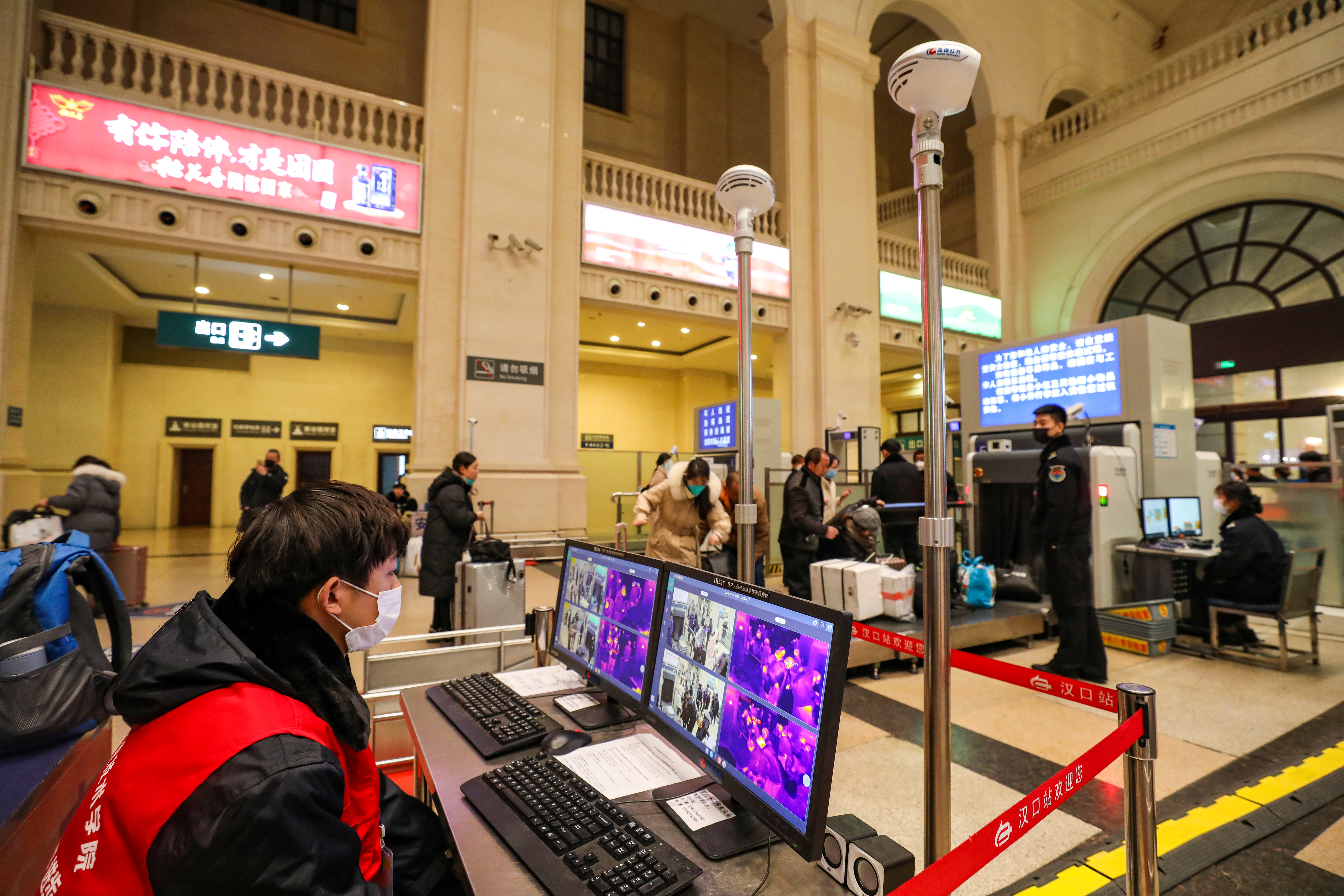 Staff members wearing masks monitor thermal scanners to detect the body temperatures of passengers passing through the Hankou Railway Station in Wuhan on Tuesday. Photo: China Daily via Reuters Staff members wearing masks monitor thermal scanners to detect the body temperatures of passengers passing through the Hankou Railway Station in Wuhan on Tuesday. Photo: China Daily via Reuters