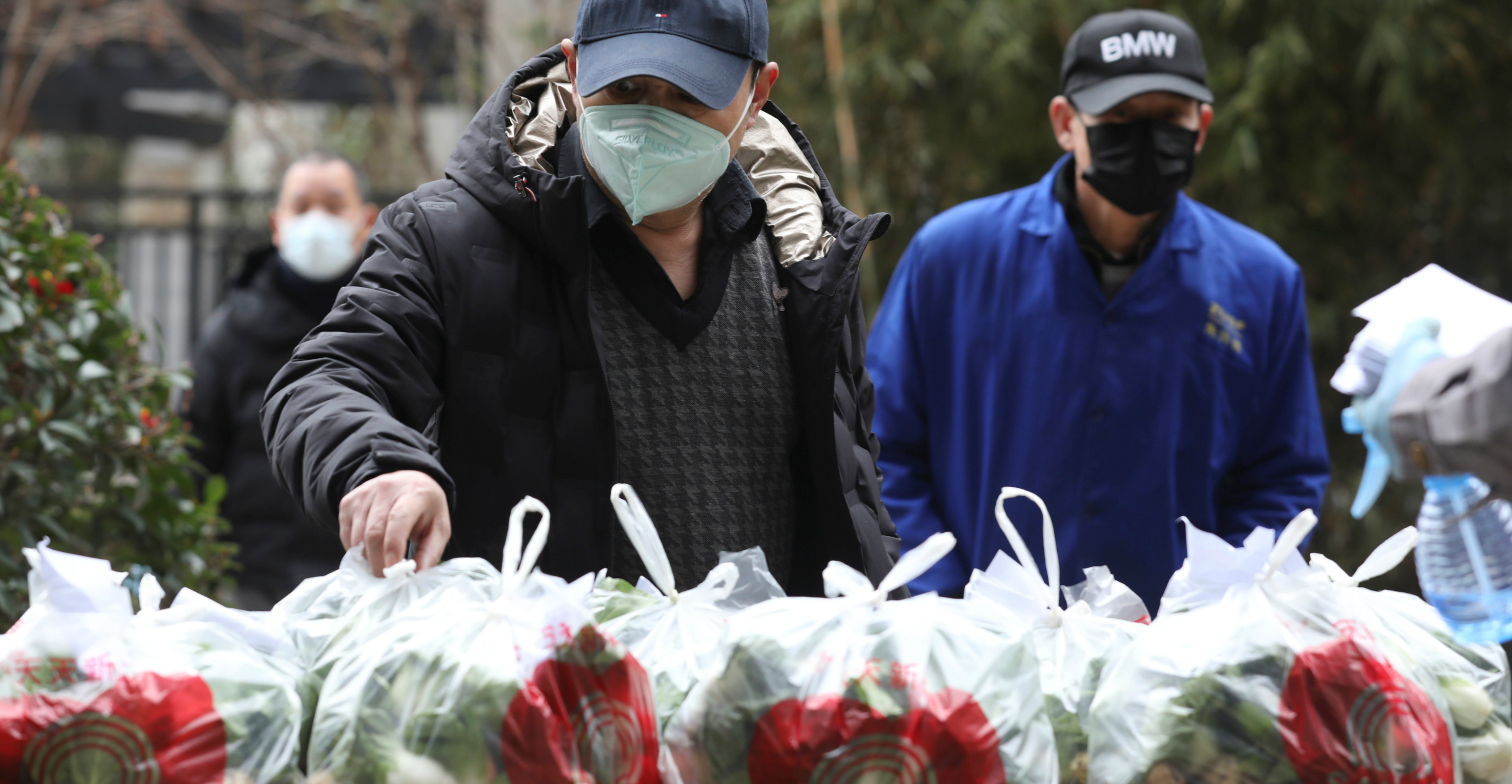 Residents wearing face masks collect free vegetables from community workers at a residential compound in Wuhan on Tuesday. Photo: China Daily via Reuters Residents wearing face masks collect free vegetables from community workers at a residential compound in Wuhan on Tuesday. Photo: China Daily via Reuters