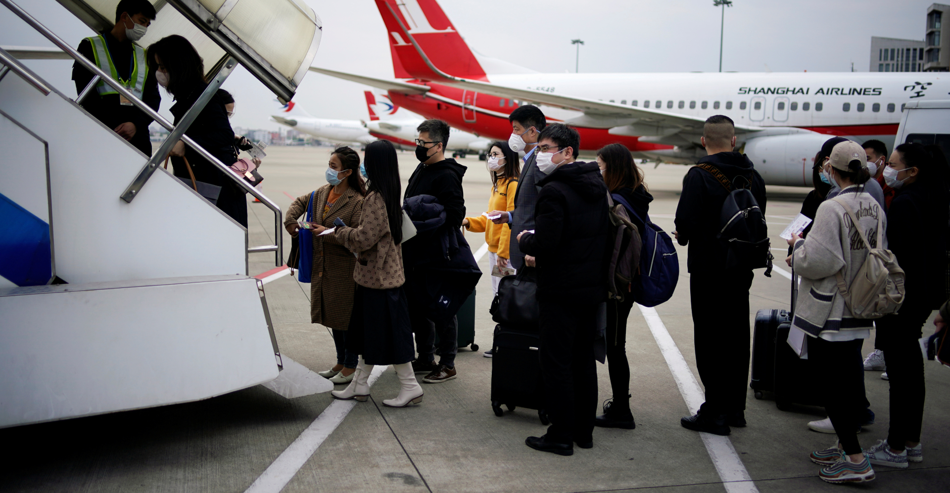 Passengers wearing face masks prepare to board an aircraft at Shanghai Hongqiao International Airport on Wednesday. Photo: Reuters Passengers wearing face masks prepare to board an aircraft at Shanghai Hongqiao International Airport on Wednesday. Photo: Reuters