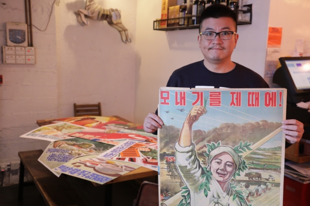 黃禮智手持的海報反映出，北韓無時無刻都處於戰爭狀態，種田都要「草木皆兵」隱藏自己。　(何澤攝)