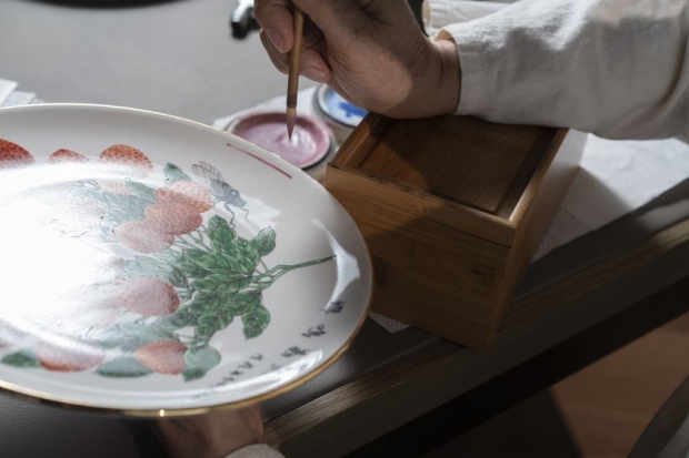 許恩福師傅示範以箱作枕手，繪畫圓形。